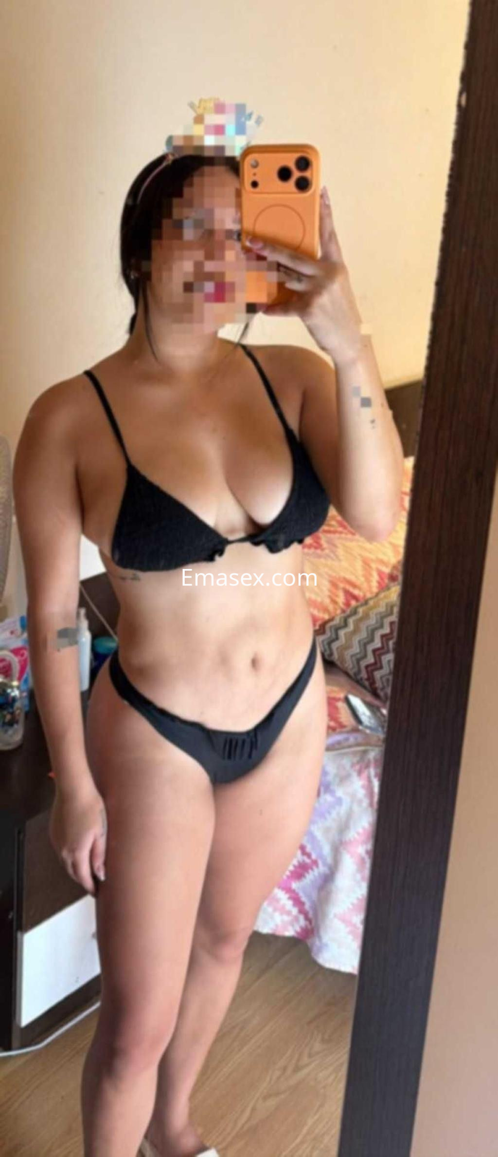 Puta posando frente al espejo con un bikini negro en un entorno doméstico en Madrid.
