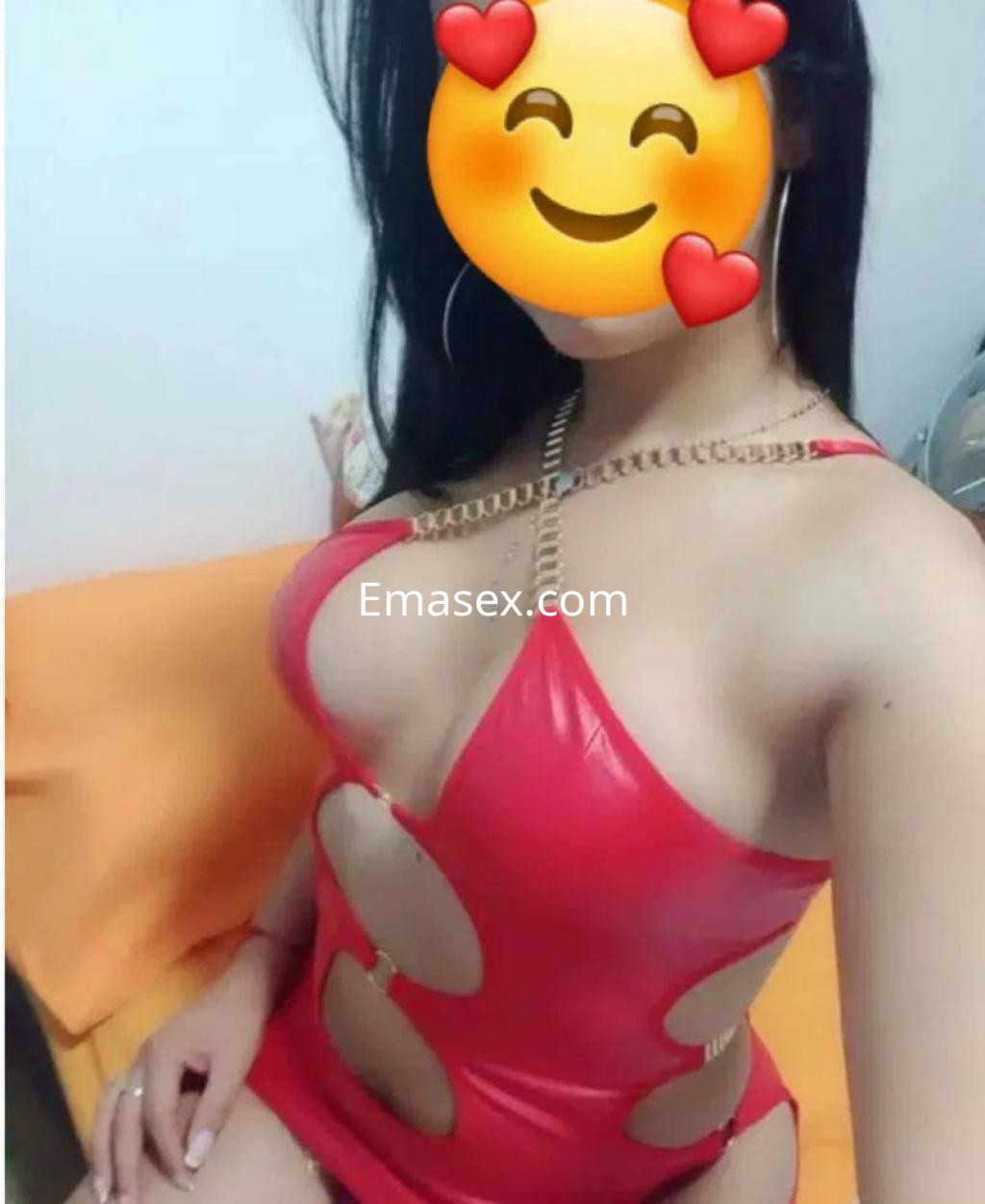 Puta en Granada viste un ceñido traje rojo con cortes, mostrando una figura atractiva en un entorno acogedor.