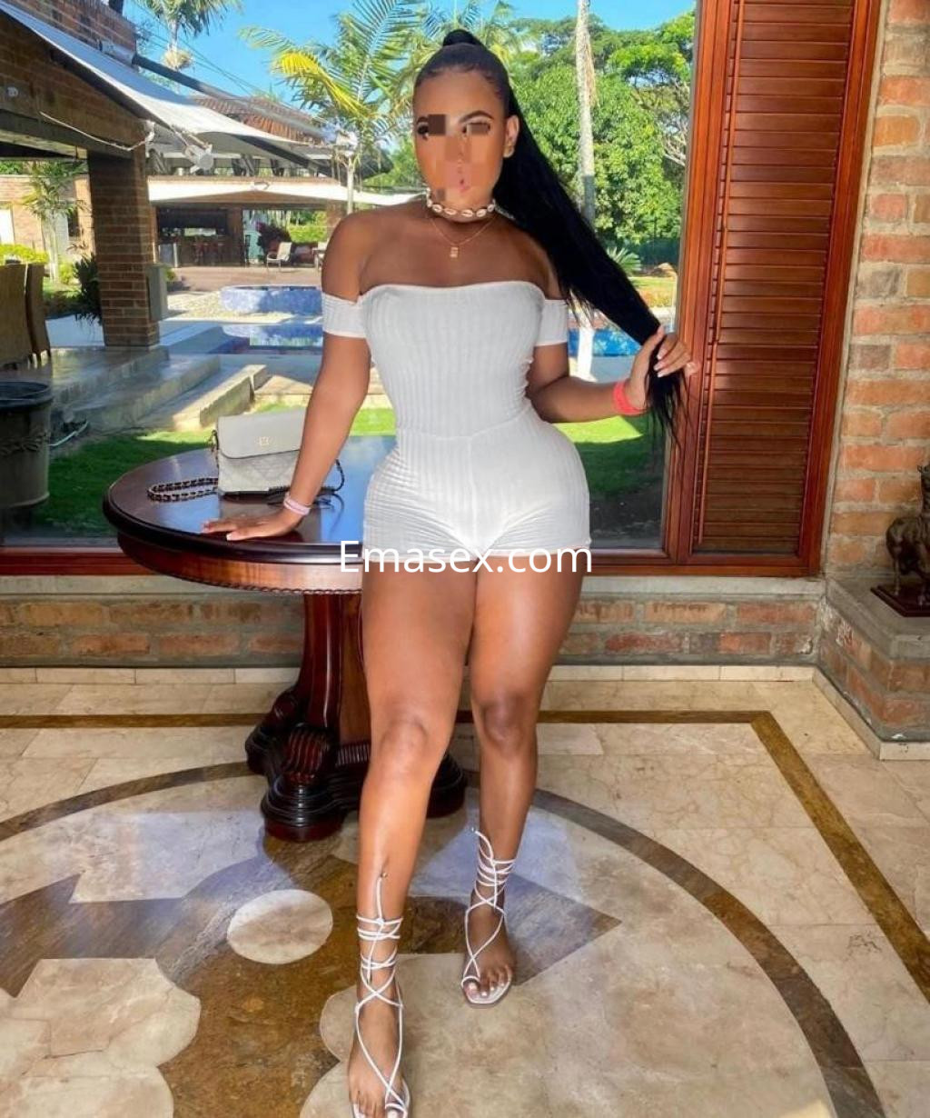 La escort se muestra en Alicante, luciendo un conjunto blanco ajustado y sandalias, con cabello largo y lacio.