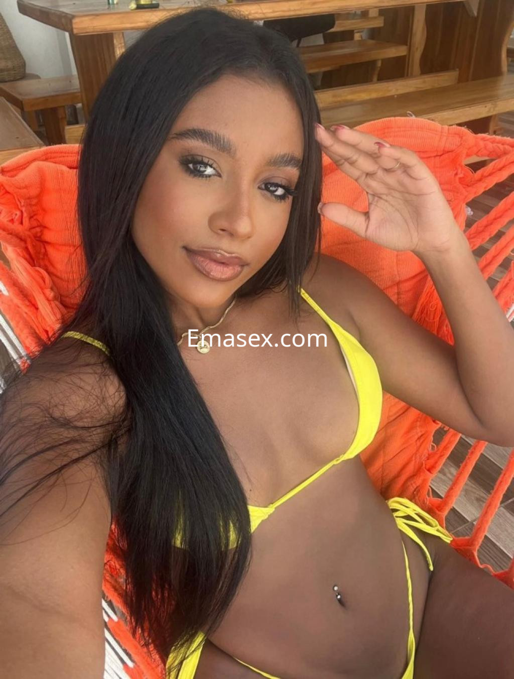 Puta de piel morena con pelo largo y lacio, lleva un bikini amarillo mientras posa en un ambiente relajado en Castellón.