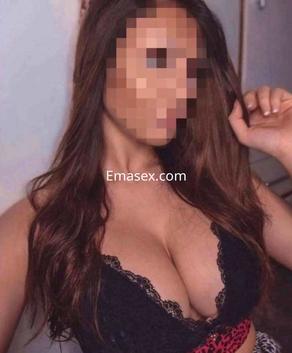 Puta con cabello largo y castaño, luciendo un sujetador negro con encaje y un fondo neutro en Girona.