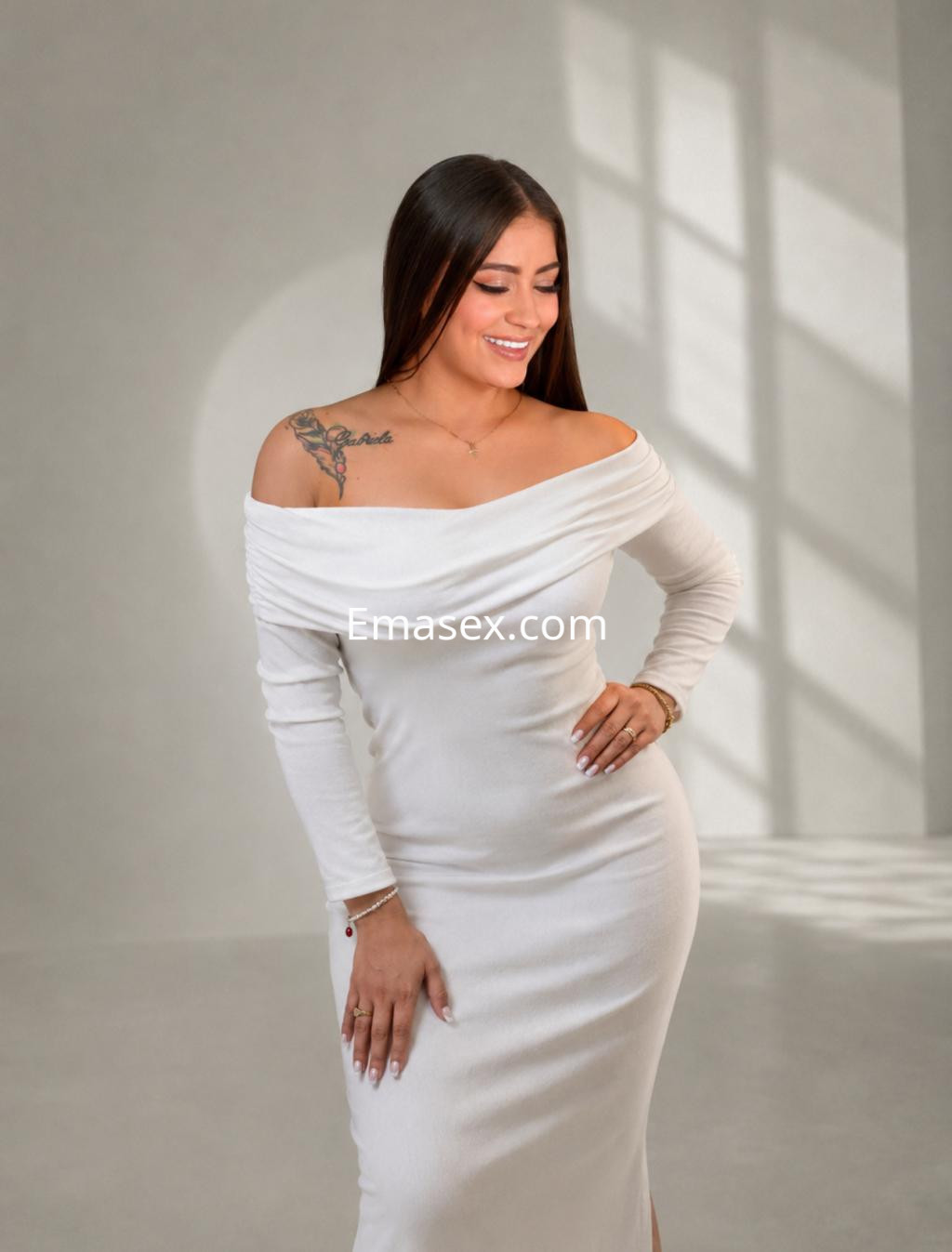 Puta en Tenerife, con cabello largo y lacio, viste un vestido blanco ajustado y muestra un tatuaje en el hombro.