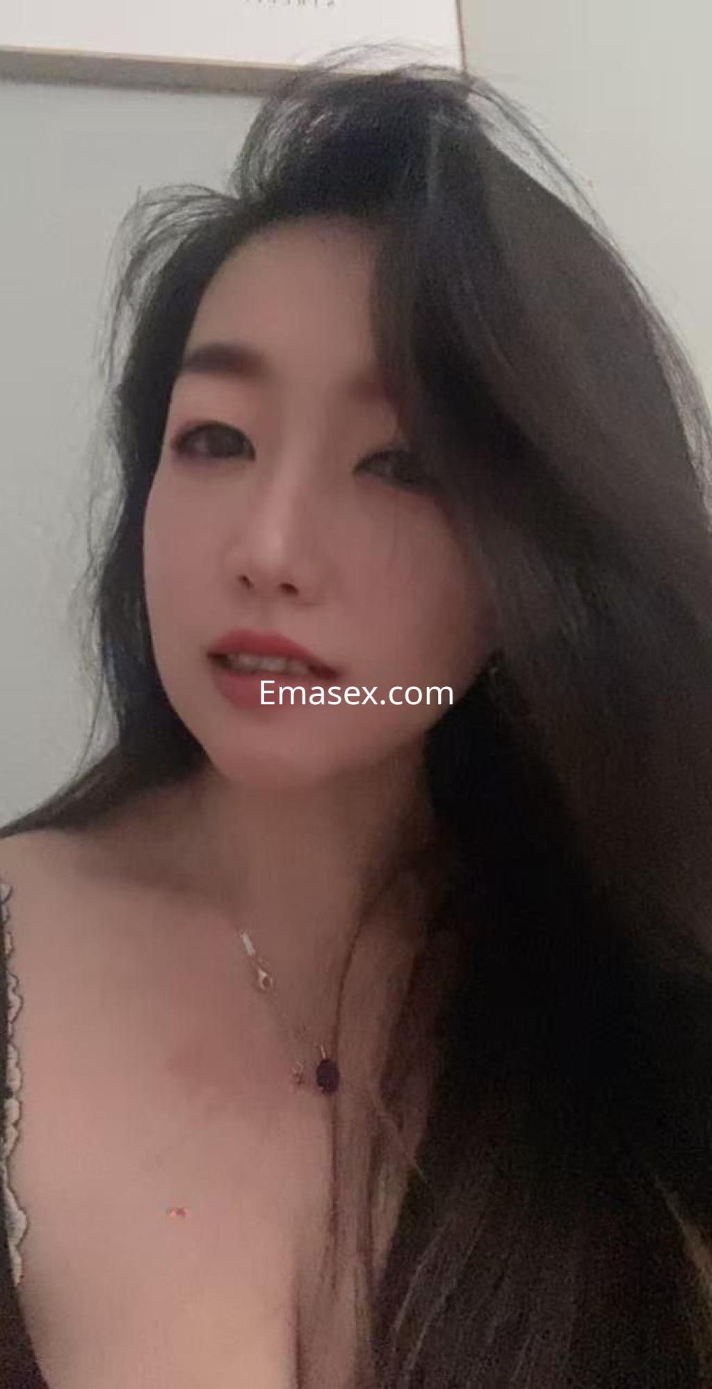 Puta con cabello largo y oscuro, luciendo un escote sutil en Zaragoza, con una expresión seductora.