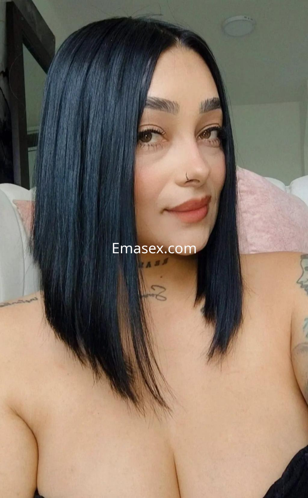 Puta en Zaragoza, con cabello lacio y oscuro, posando en primer plano con un escote y tatuajes visibles.