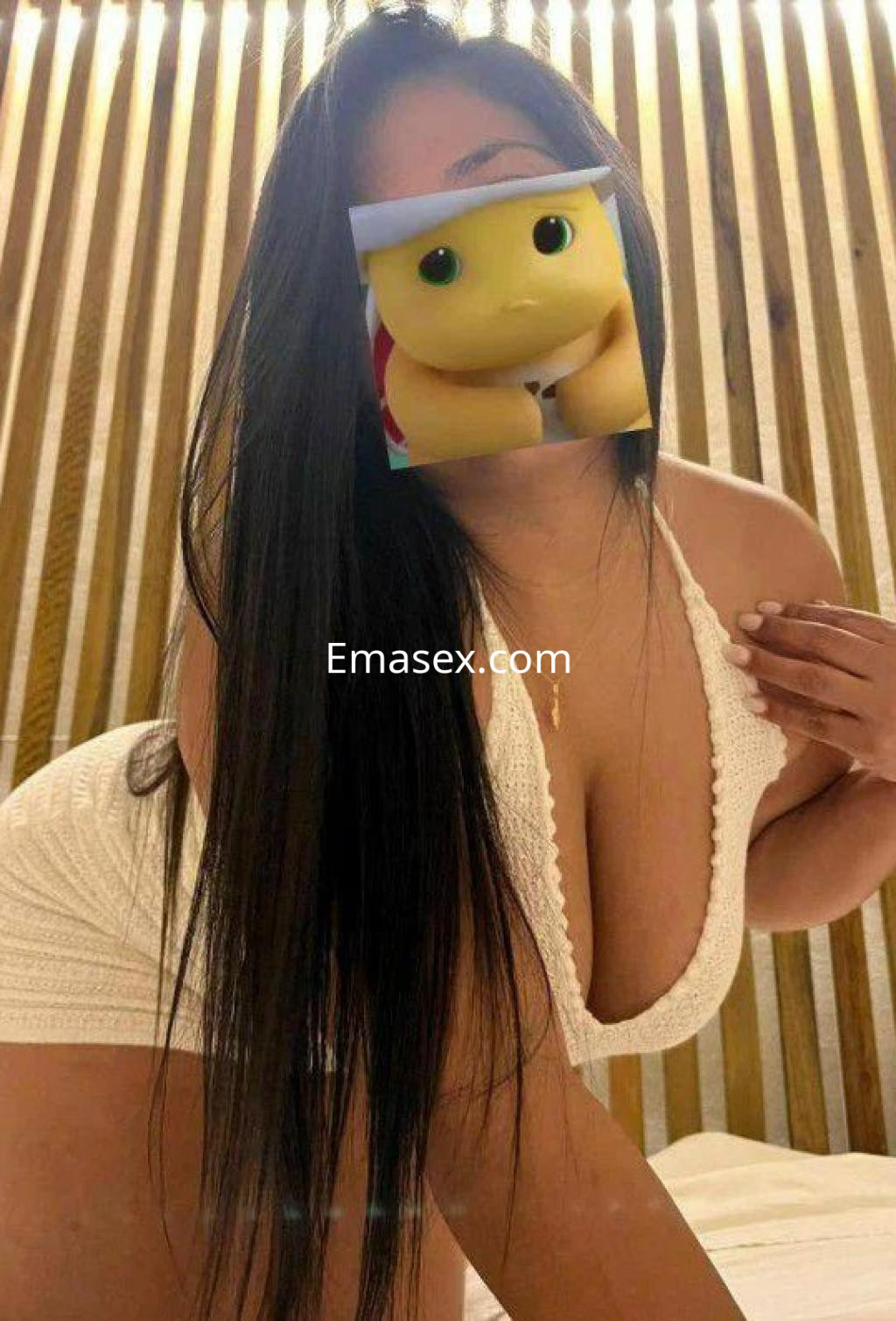 Puta en Madrid con un vestido blanco ajustado, posando en un ambiente iluminado y con cabello largo y lacio.