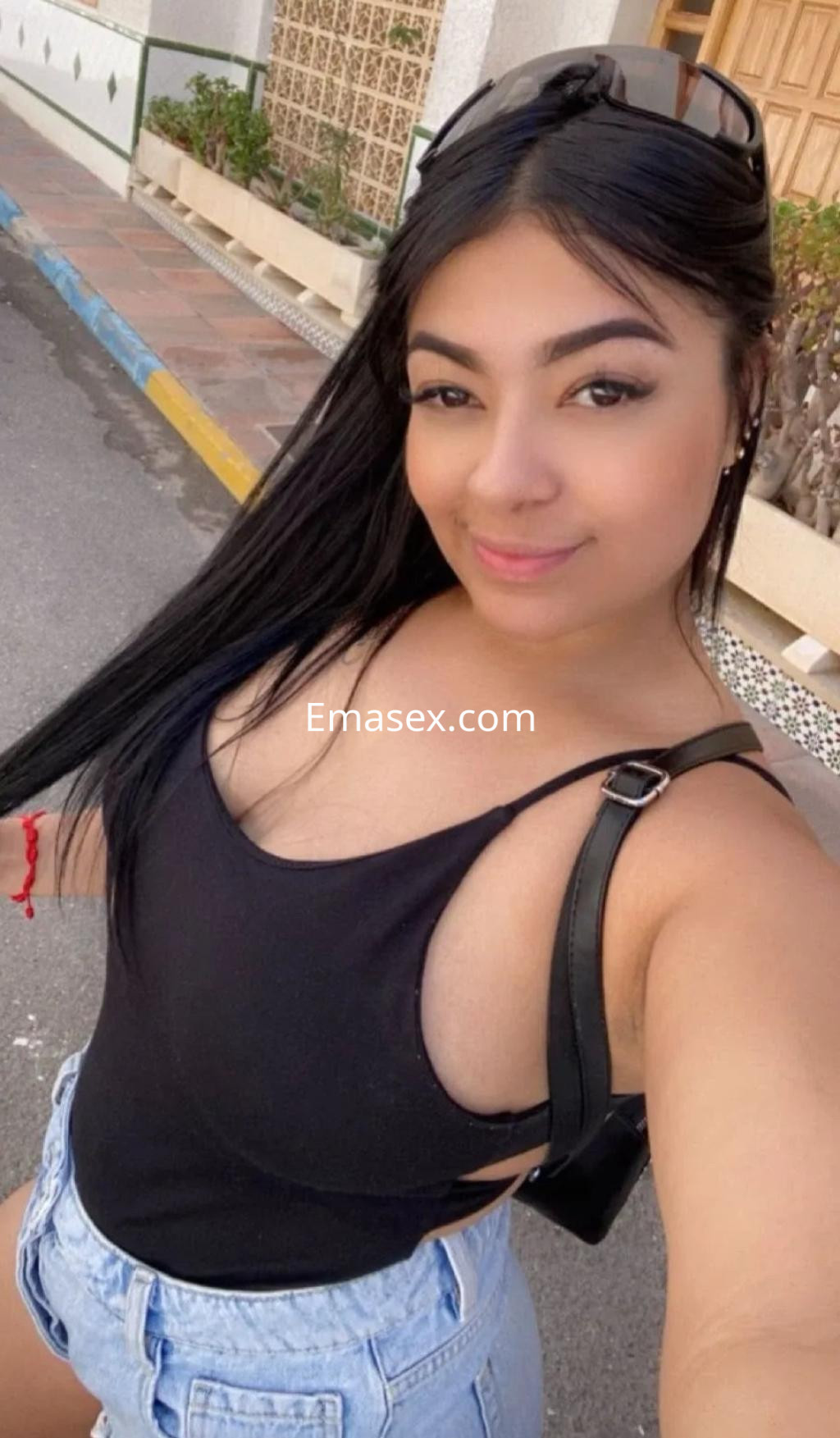 La puta luce un body negro y shorts de mezclilla, posando con una sonrisa en Alicante.
