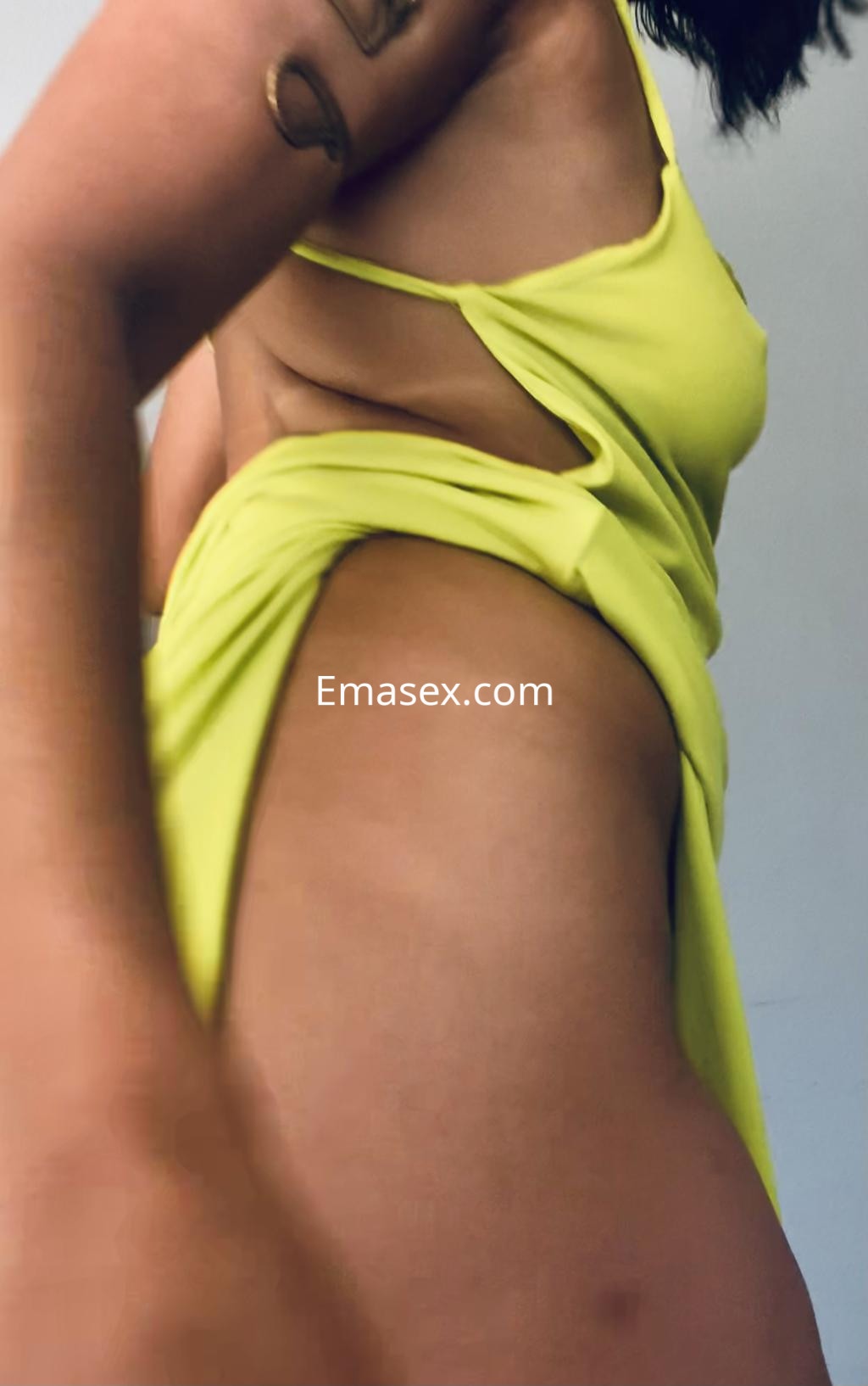 Puta de Irún con un vestido verde fosforescente que revela su figura, posando con un gesto seductor.