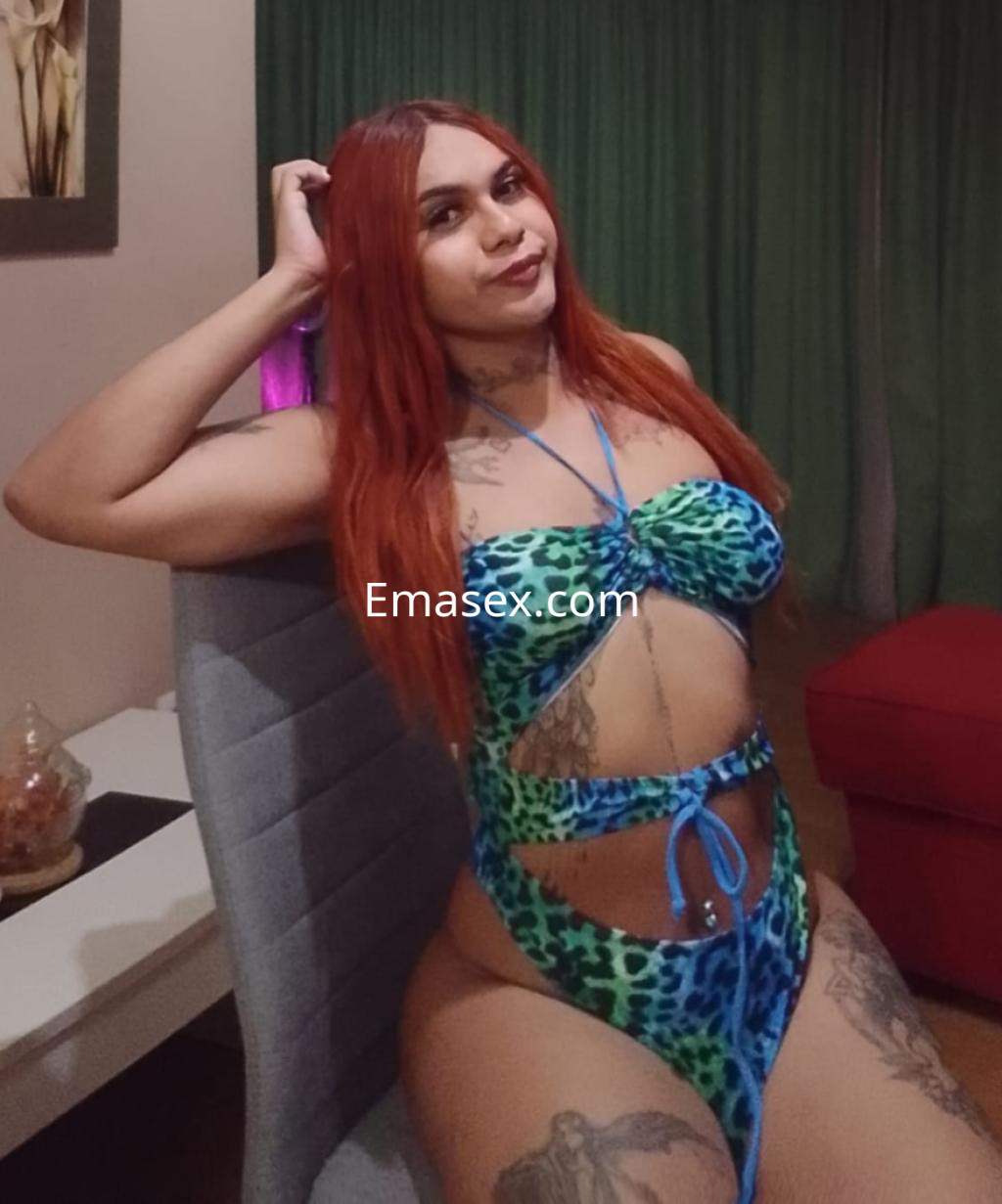 Puta trans en Madrid, posando en un bikini de leopardo azul y verde, con cabello largo y rojizo en un ambiente acogedor.