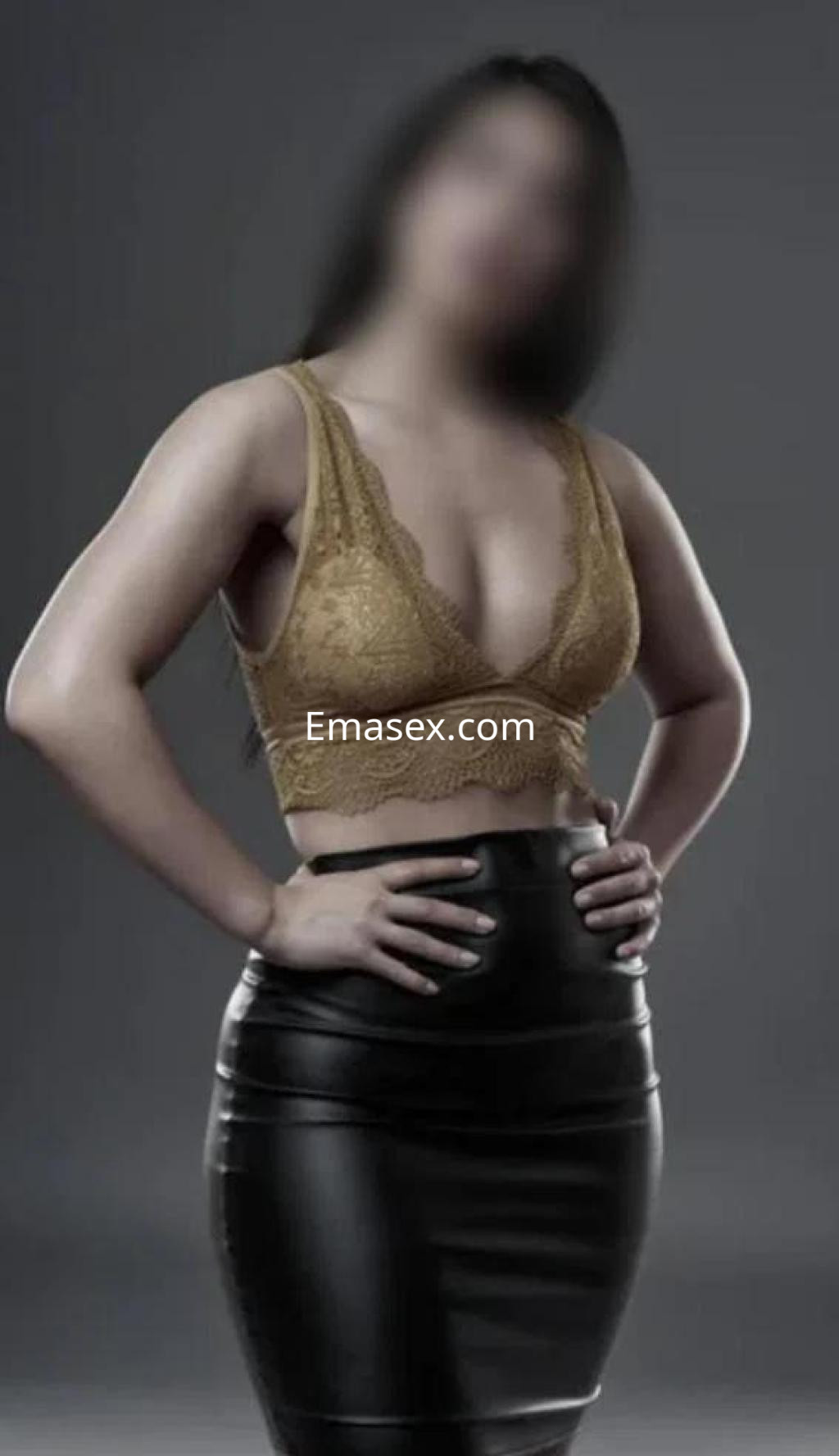 Puta en Albacete posando con un top de encaje dorado y una falda de cuero ajustada, mostrando confianza.