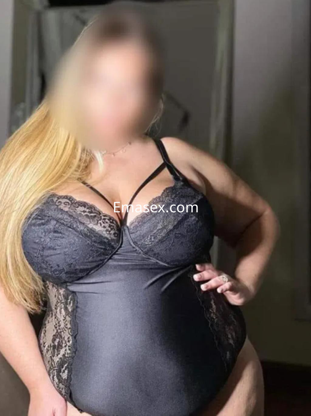 Escort en León posando con un body negro de encaje que resalta su figura, con cabello largo y rubio.