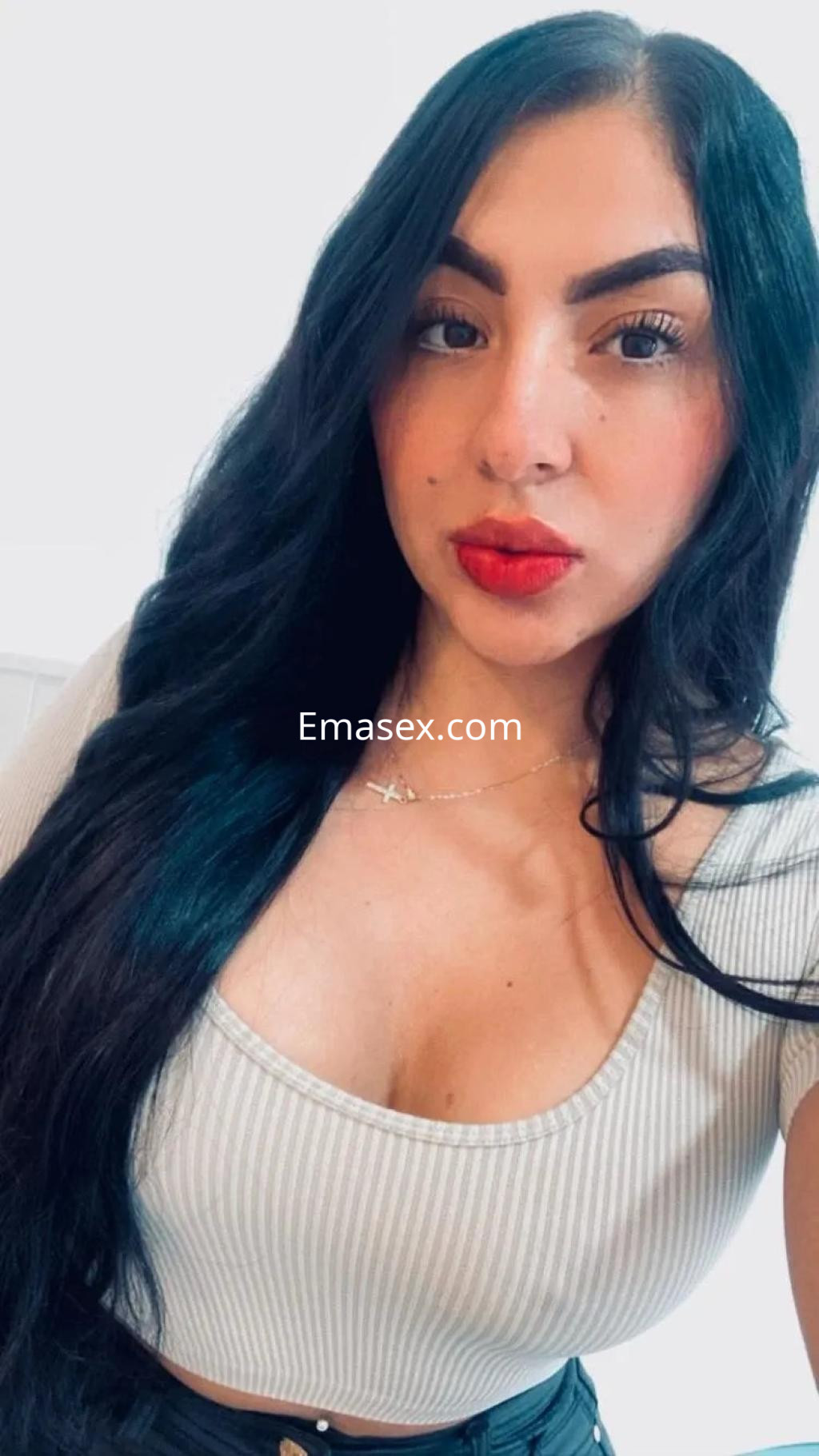 Puta en Santiago con cabello largo y oscuro, blusa ajustada de rayas y labios rojos, posando de cerca.