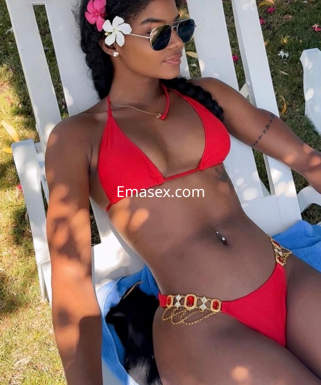 Puta posa en una tumbona al sol, vistiendo un bikini rojo y gafas de sol en un ambiente veraniego en Gijón.
