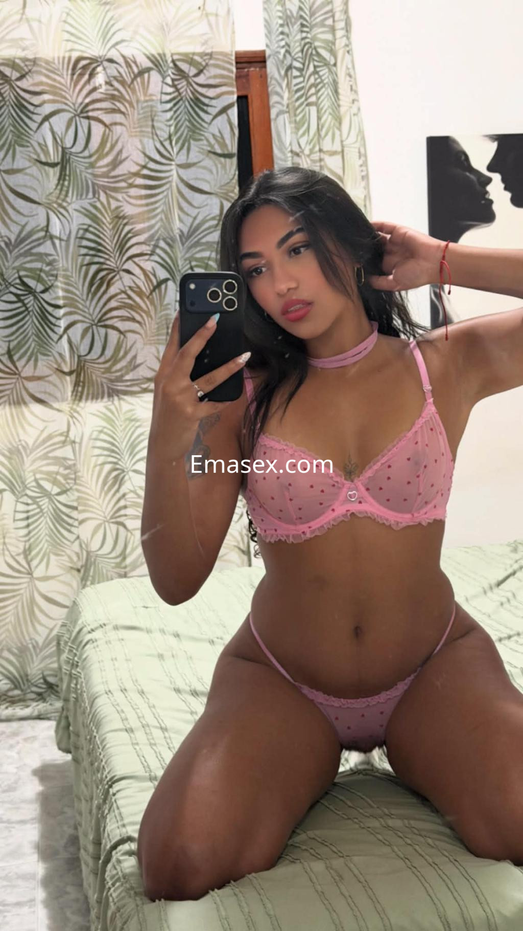 La puta en León se muestra en lencería rosa con detalles, posando sentada y con el cabello largo y suelto.