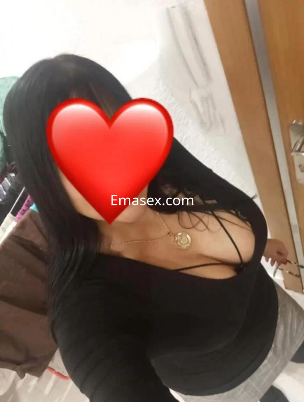 Puta en Pamplona con cabello largo y lacio, luciendo una blusa negra ajustada y una cadena al cuello.