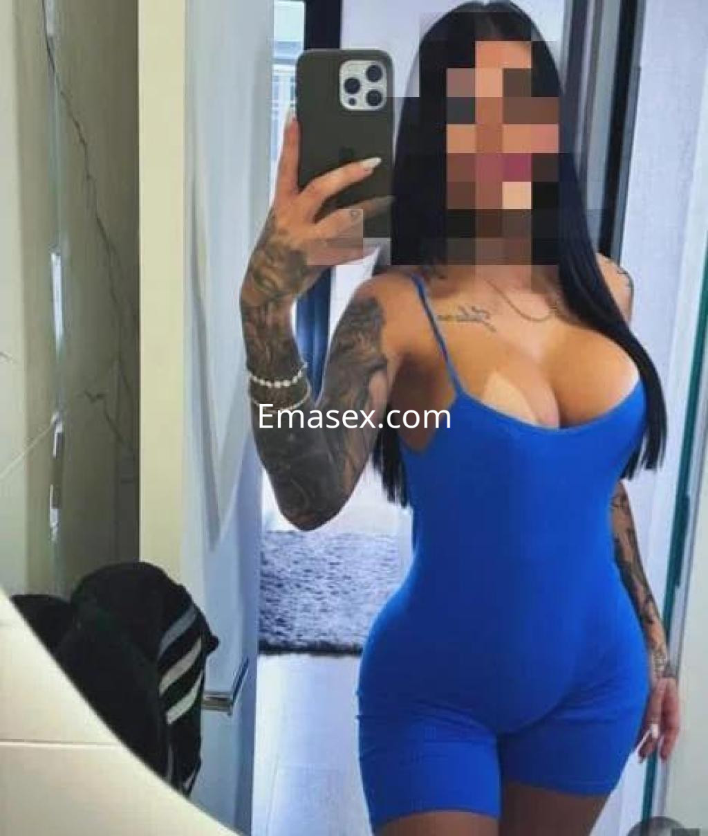 La puta se muestra en un espejo con un ajustado mono azul, destacando su figura y tatuajes en Ourense.