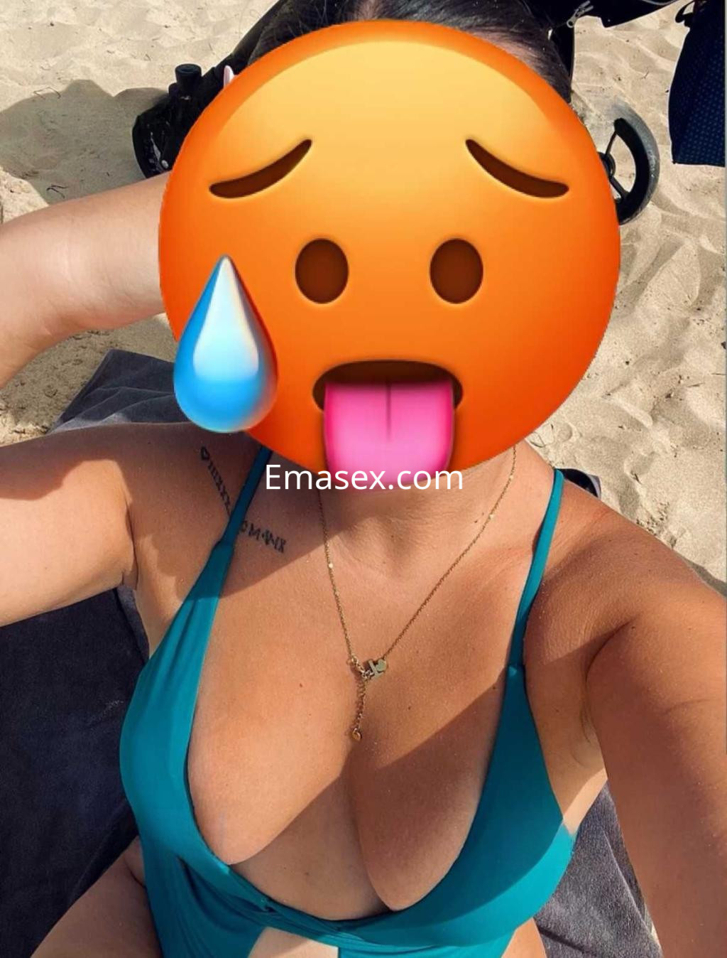 Puta en Granada posando en la playa con un bikini verde, mostrando su figura mientras toma el sol.