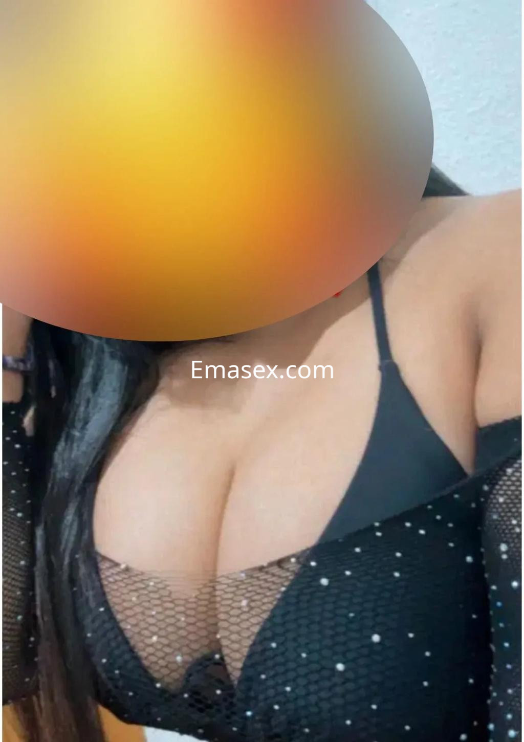 Puta en Albacete lleva un top de malla negra con brillo que resalta su figura y posa con expresión seductora.