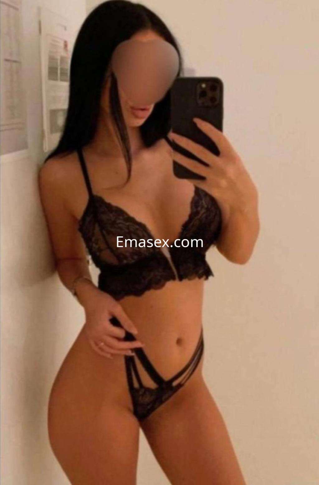 Escort en Alicante posa frente a un espejo, vistiendo lencería negra de encaje y con cabello largo y lacio.