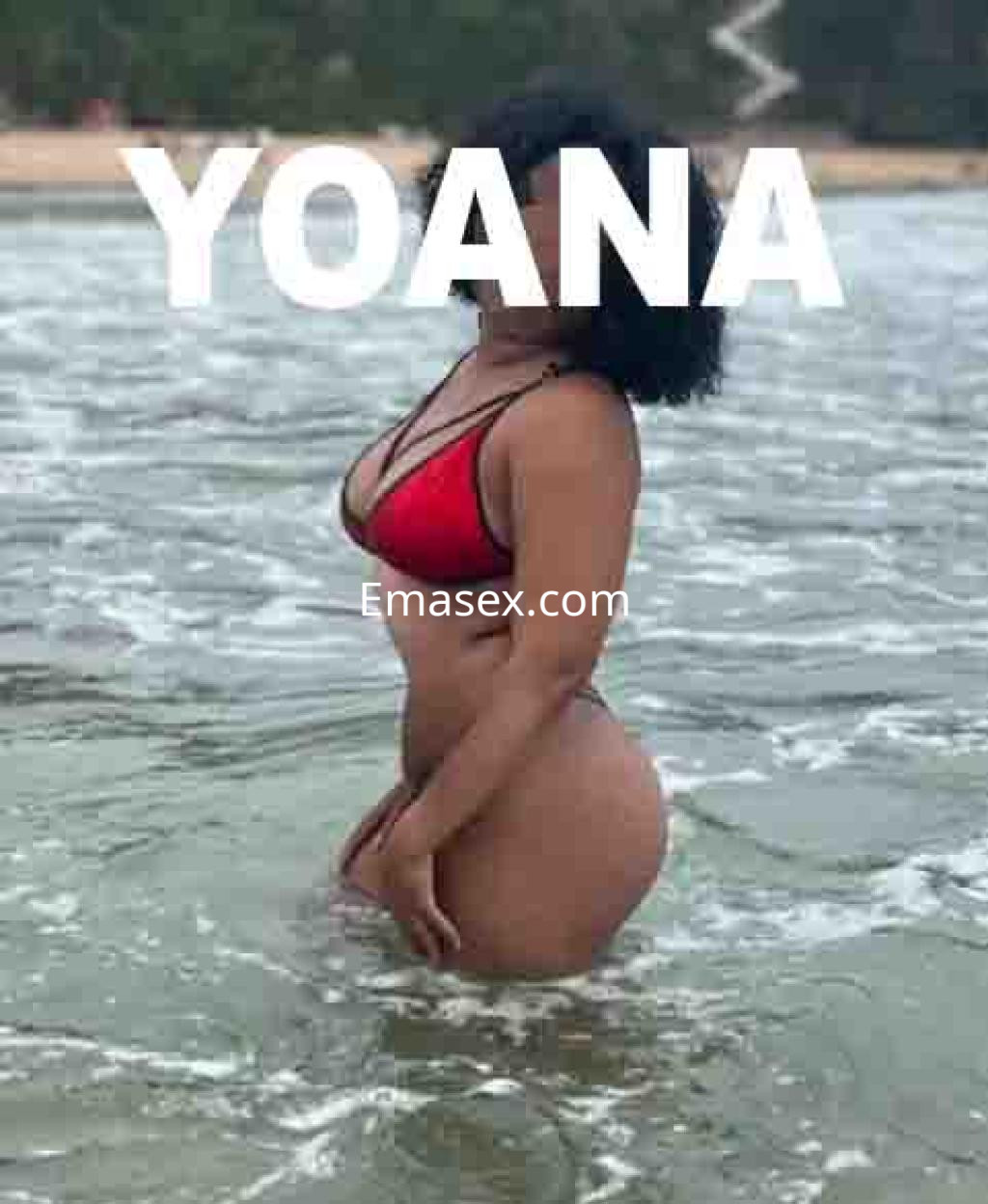 Escort de Valladolid en la playa, luciendo un bikini rojo mientras se sumerge en el agua.