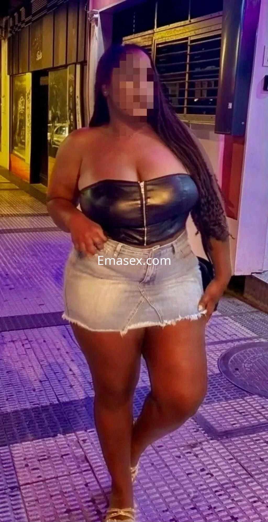 Puta posando en Coruña con un top de cuero negro y una falda de mezclilla, mostrando confianza en la noche.