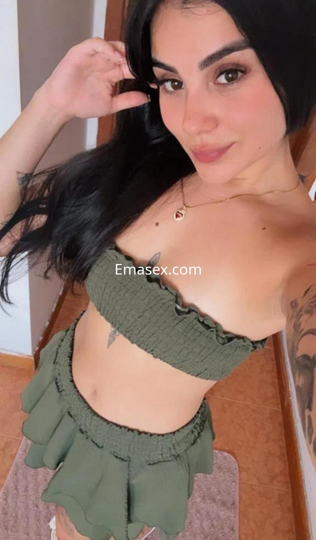 Escort en Palma de Mallorca, posa en un atuendo verde claro, mostrando su piel y con el cabello largo y oscuro.