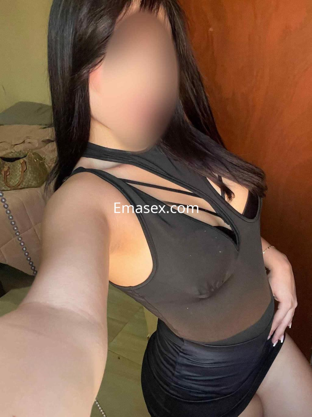 Escort en Palma de Mallorca, posando con un vestido negro ajustado y detalles de transparencia, mostrando un look elegante.
