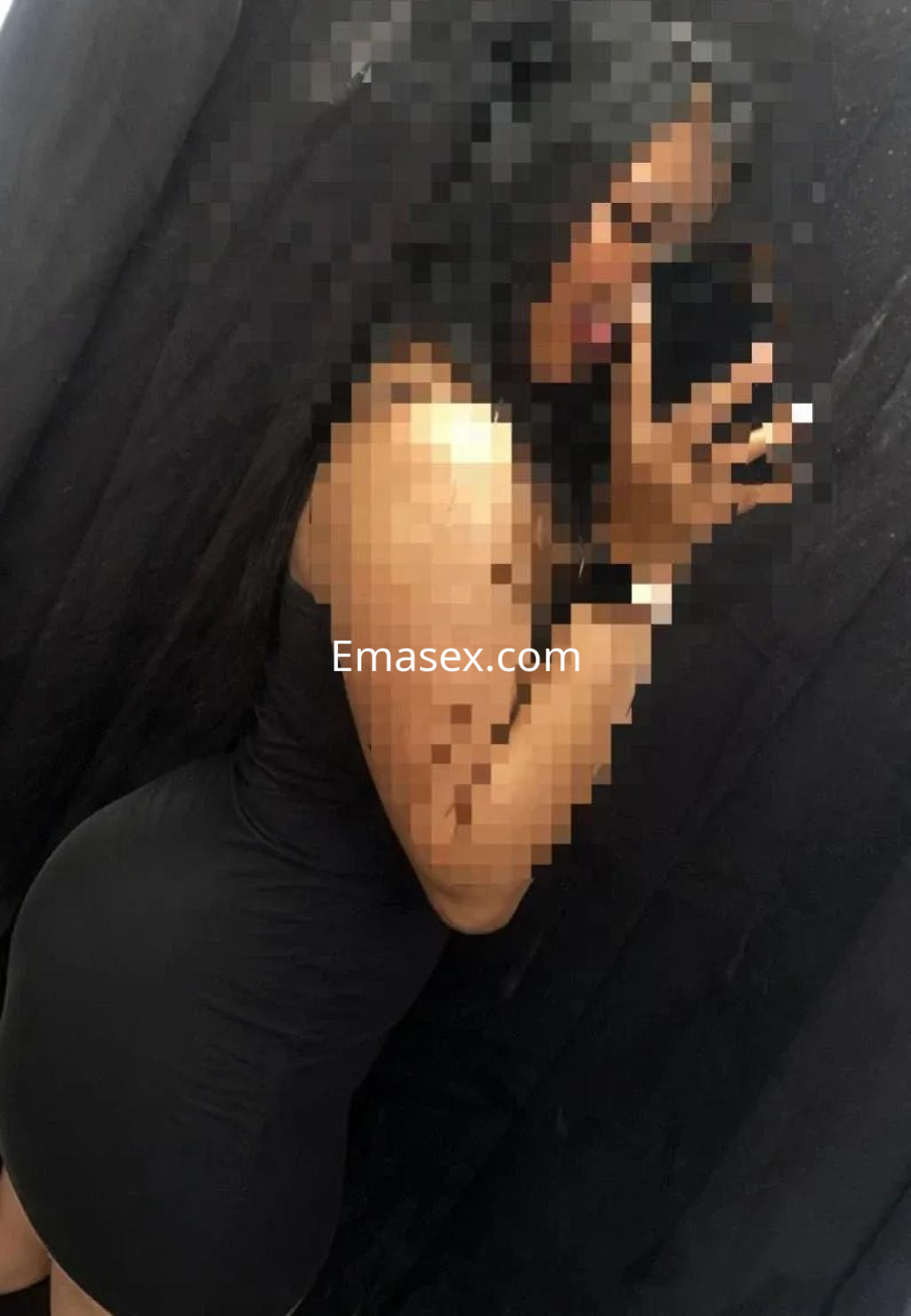 Escort en Madrid posando de perfil, vestida con un ajustado vestido negro que resalta su figura.