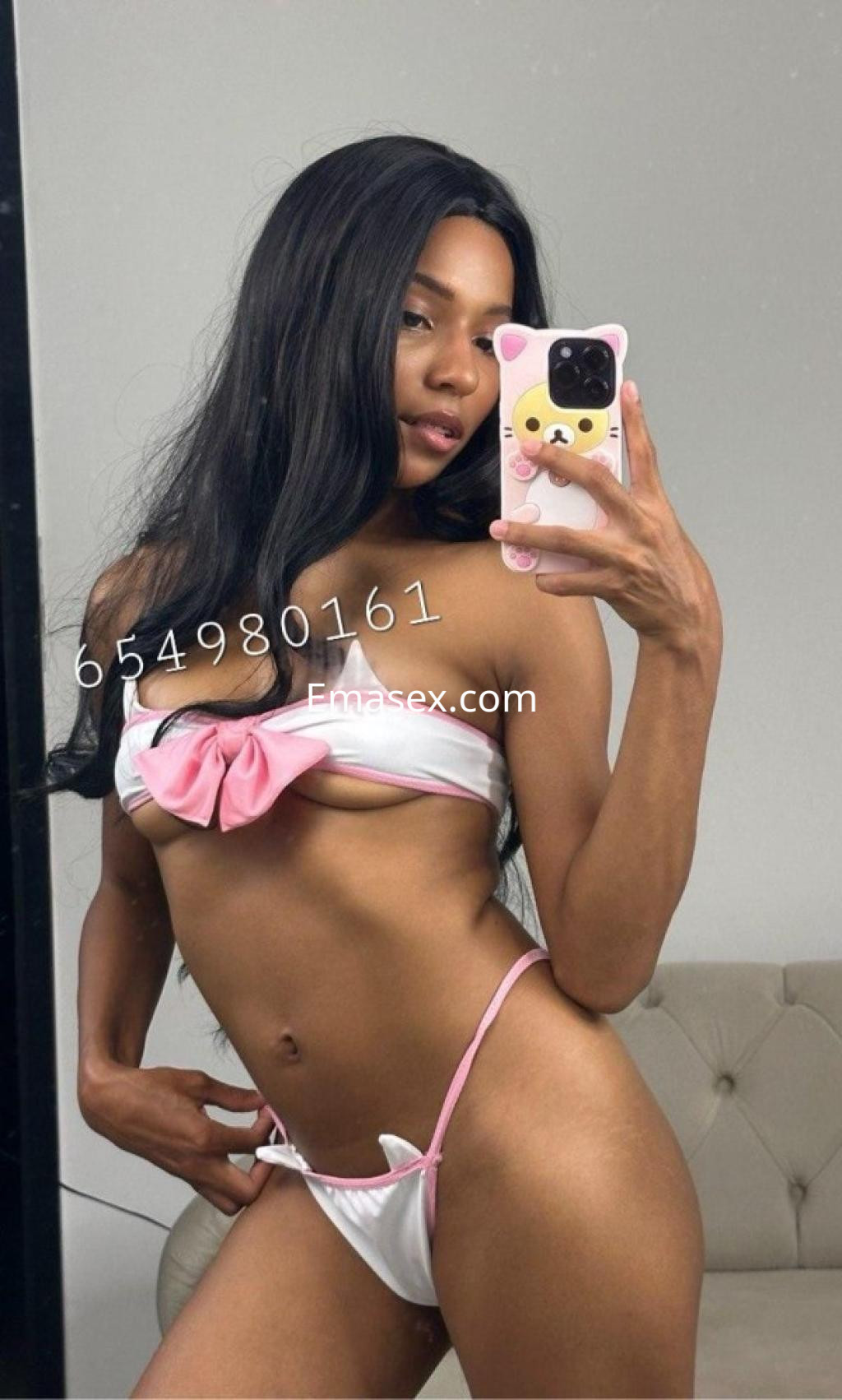 Escort en Coruña posando con un bikini blanco y rosa, mostrando su figura en un espejo.