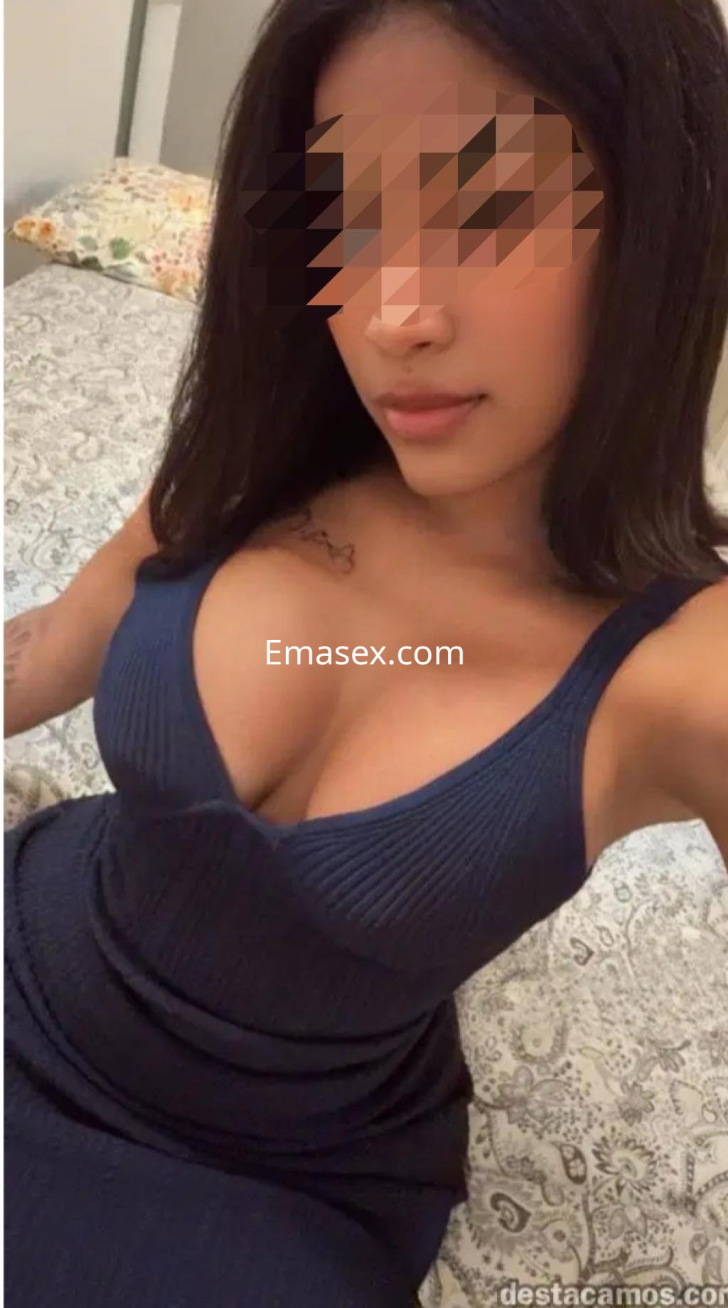 Escort en Santiago posando con un vestido azul ajustado, mostrando un escote pronunciado y cabello lacio.