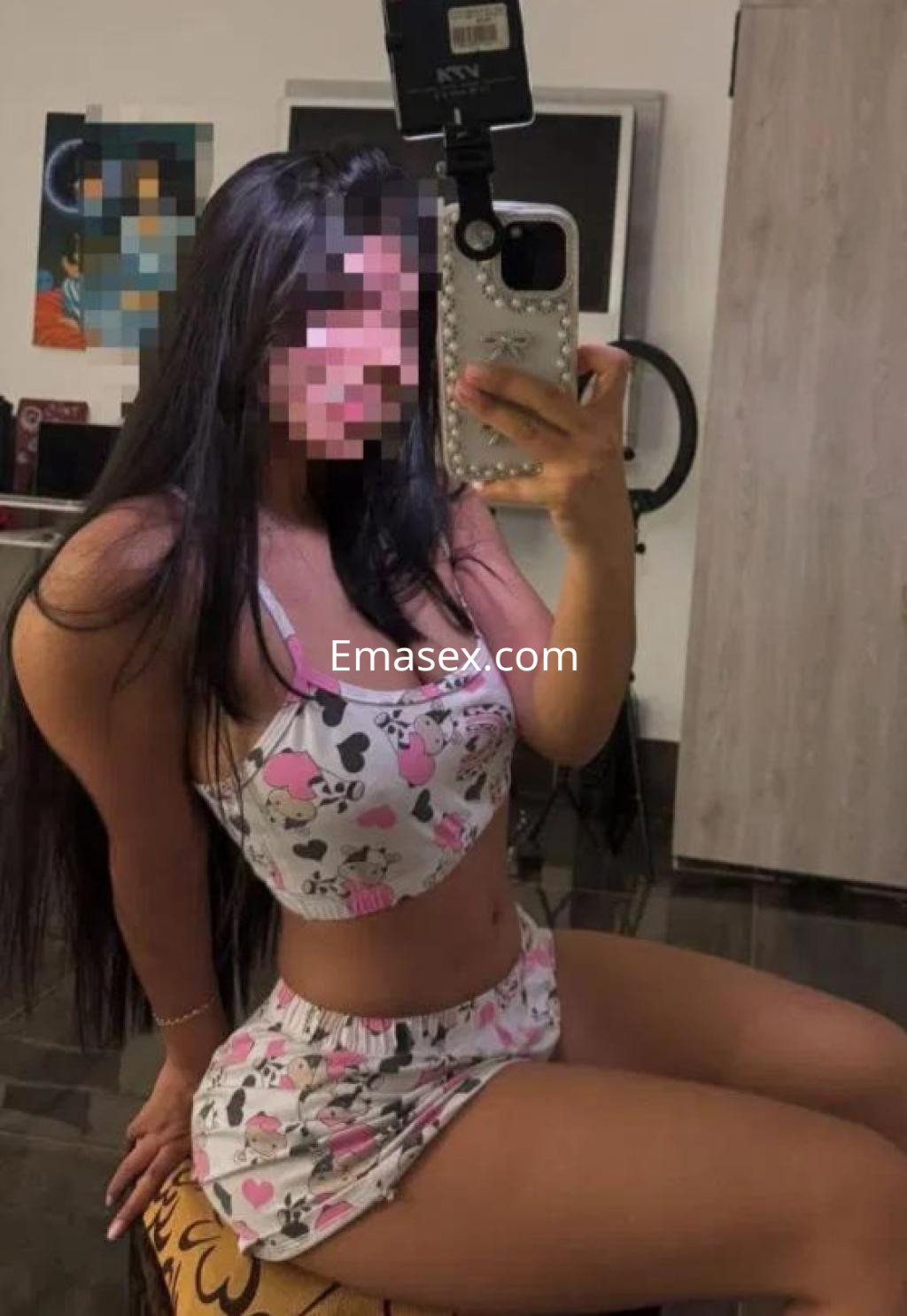 Escort en Madrid, posando de frente en ropa interior con estampado de dibujos, sentada en un taburete.