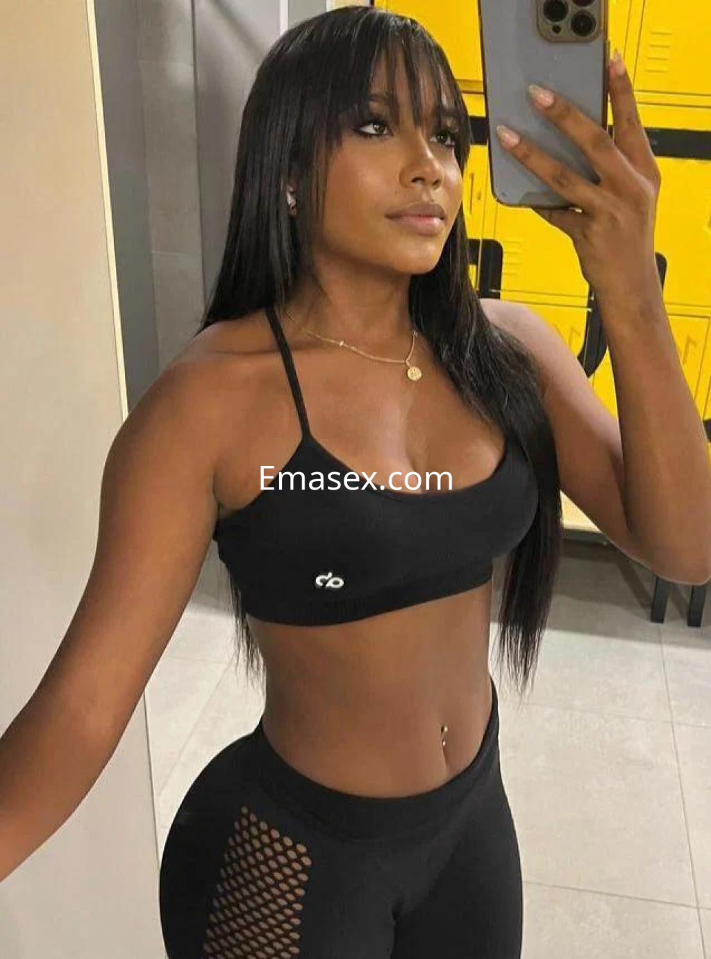 Escort en Logroño con cabello largo y lacio, vistiendo top negro y leggings ajustados, posando en un espejo.