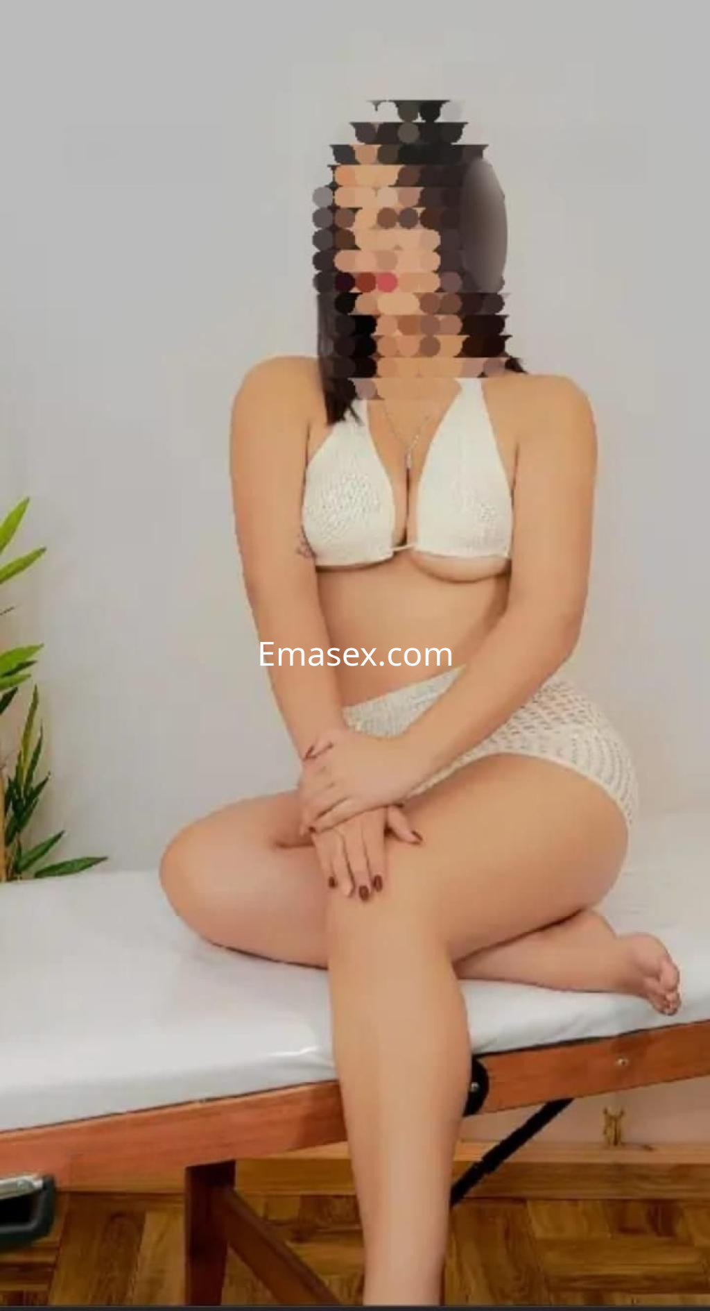Puta en Toledo sentada sobre una mesa, vistiendo un bikini blanco y mostrando una pose sugestiva.