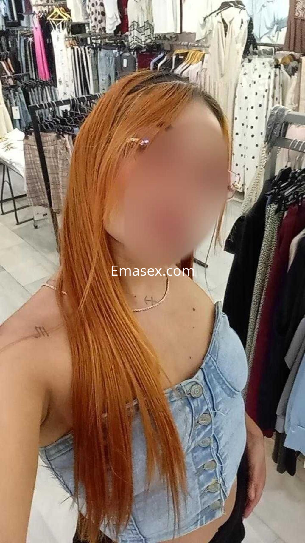Puta con cabello largo y naranja, vistiendo un top de mezclilla, en una tienda de ropa en Murcia.