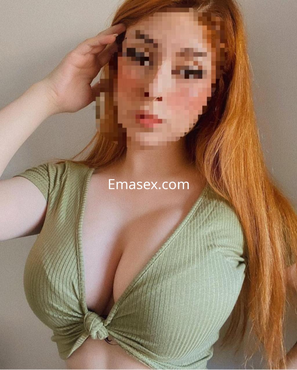 Puta con cabello largo y lacio de color naranja, viste una blusa verde ajustada que resalta su figura en Granada.