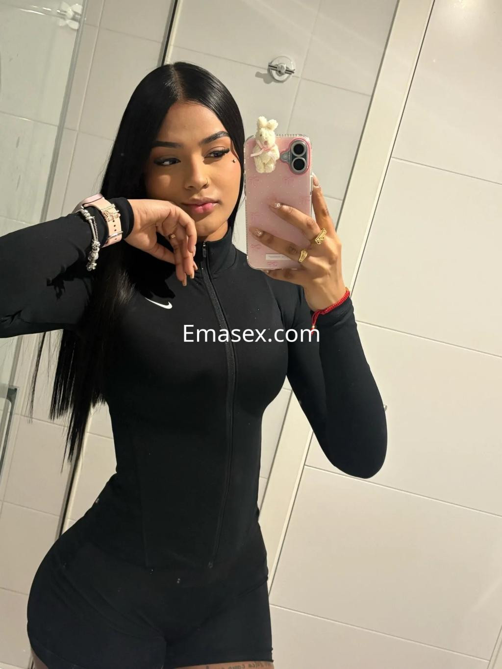 La puta en Valencia luce un ajustado traje negro de cuerpo entero, mostrando su cabello largo y liso.