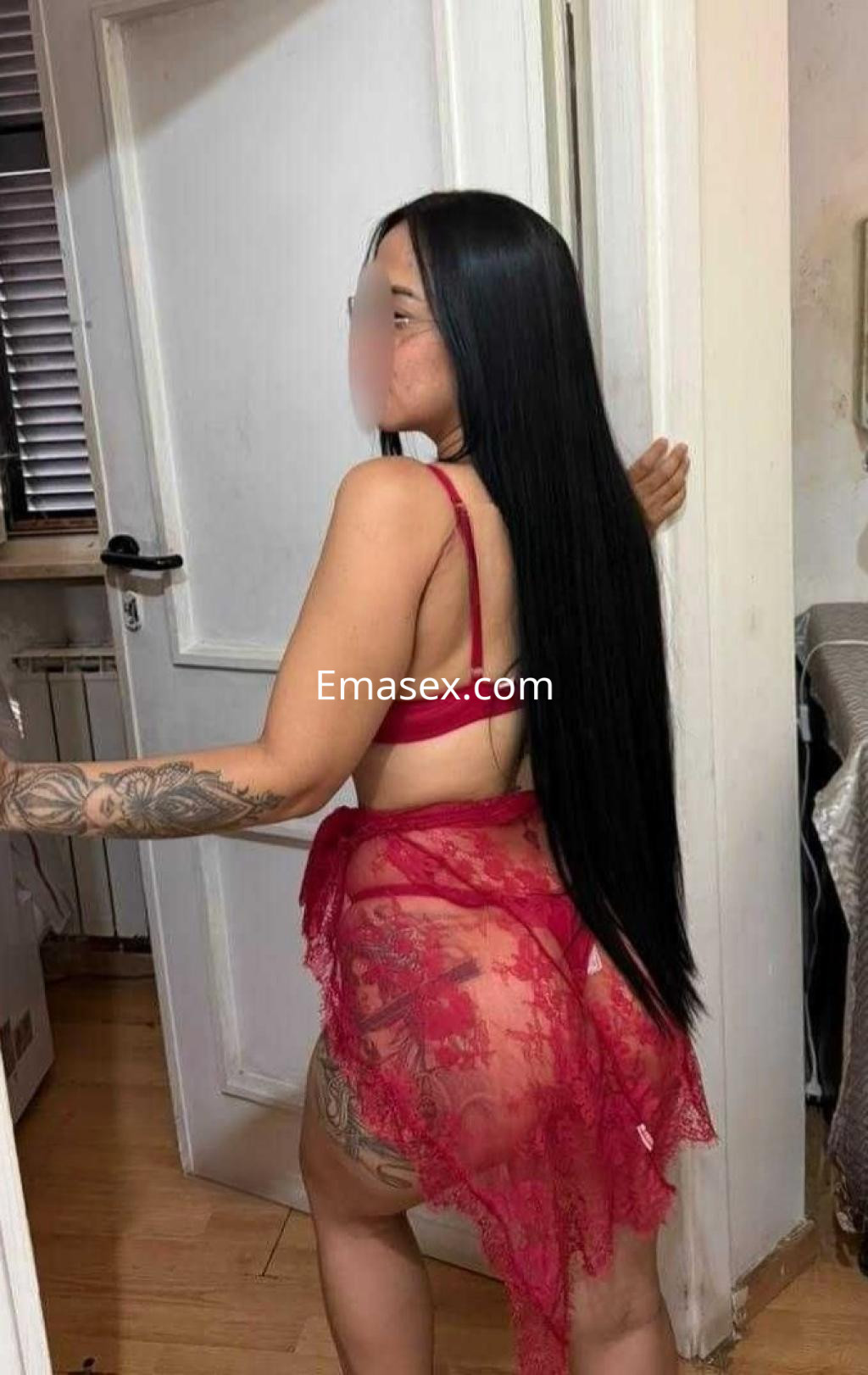 Puta en Cáceres con cabello largo y lacio, vistiendo un conjunto de lencería roja y una falda de encaje.