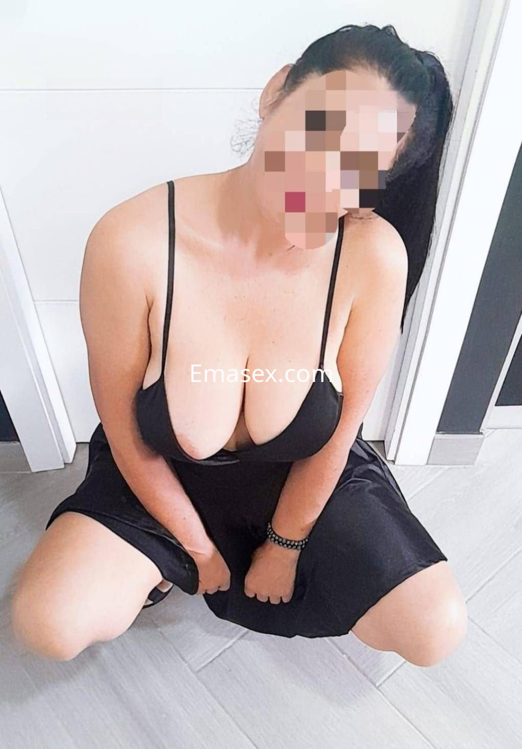 Puta en Cádiz, posando en una habitación con un vestido negro de tirantes que acentúa su figura.