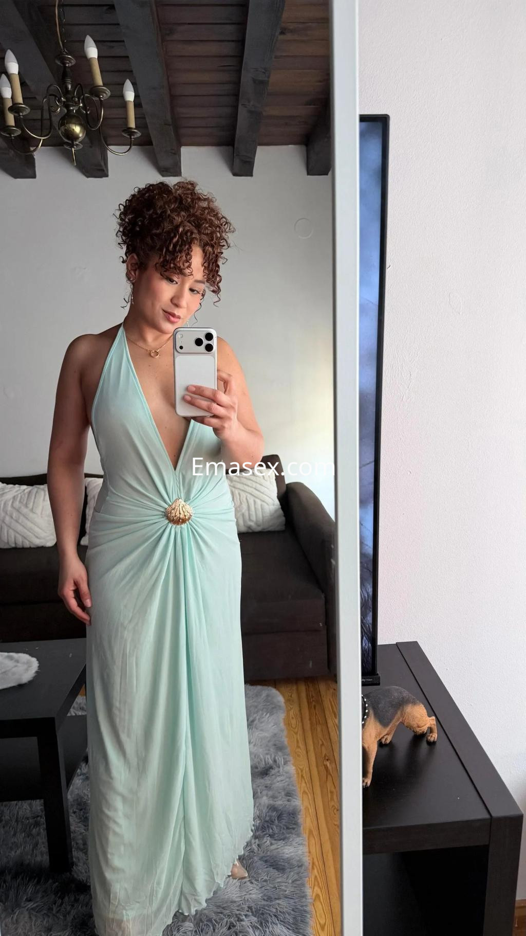 La puta en Cádiz luce un vestido largo de color verde claro, con un escote pronunciado y cabello rizado.