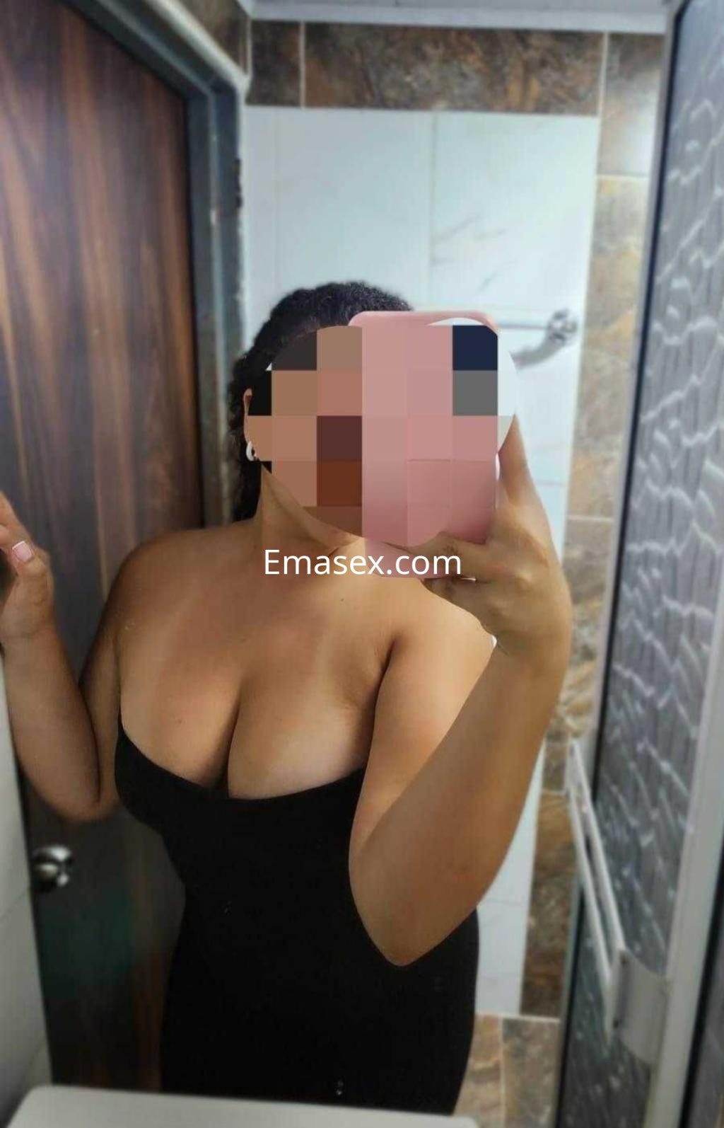 La puta se toma una selfie en el baño, luciendo un vestido negro ajustado que resalta su figura en Valencia.