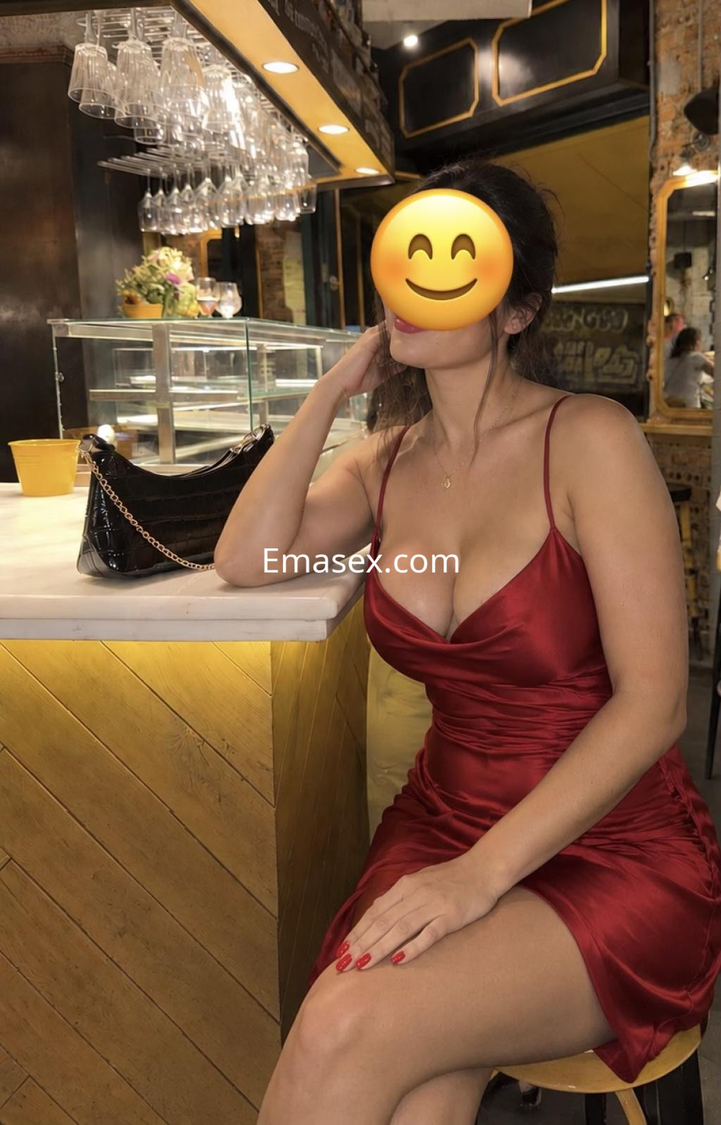 Puta sentada en una barra, viste un vestido rojo satinado y tiene el cabello recogido, en un ambiente elegante de Bilbao.