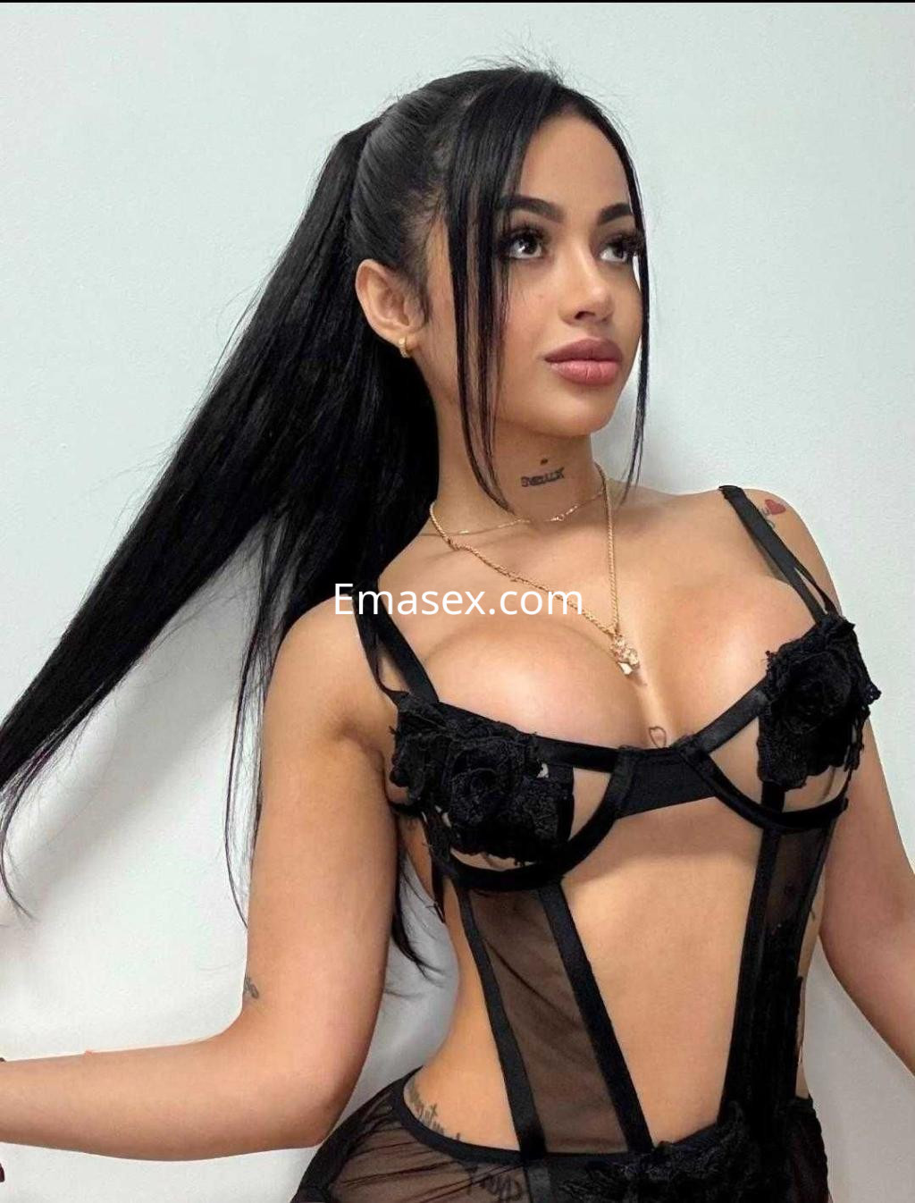 Escort en Cádiz con cabello largo y oscuro, vistiendo lencería negra transparente con detalles de flores.