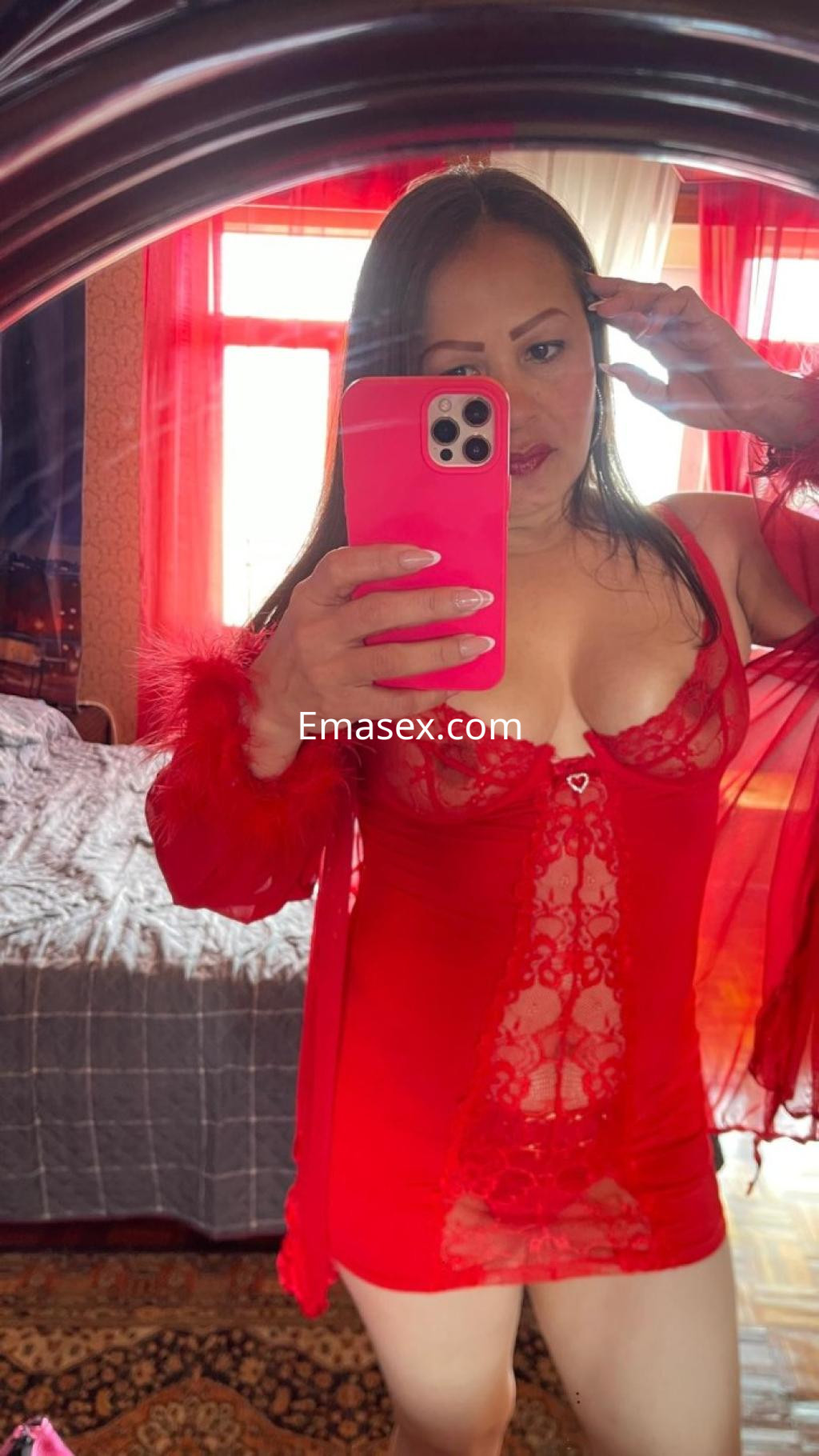 Puta en Coruña se toma una selfie en un vestido rojo transparente con detalles de encaje en un ambiente acogedor.