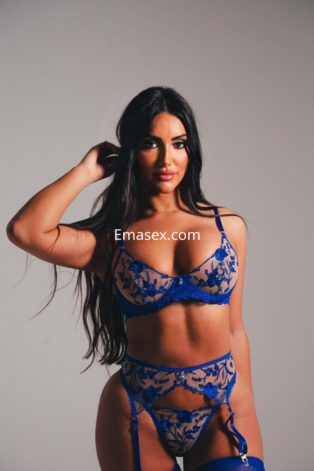 Puta con cabello largo y oscuro, viste un conjunto de lencería azul con detalles de encaje en Ibiza.