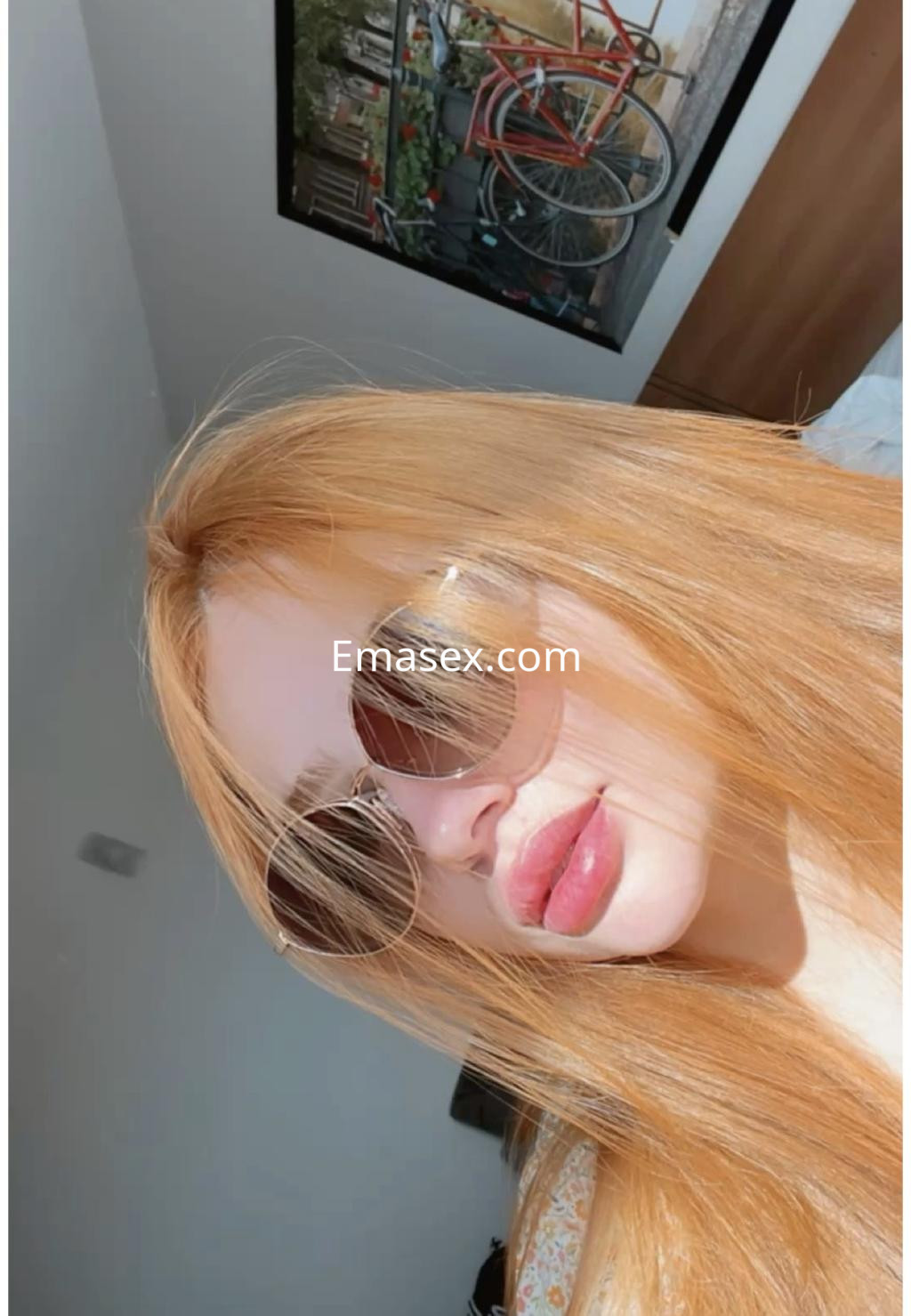 Puta con cabello largo y rubio, usando gafas de sol, posa en un ambiente luminoso de Logroño.