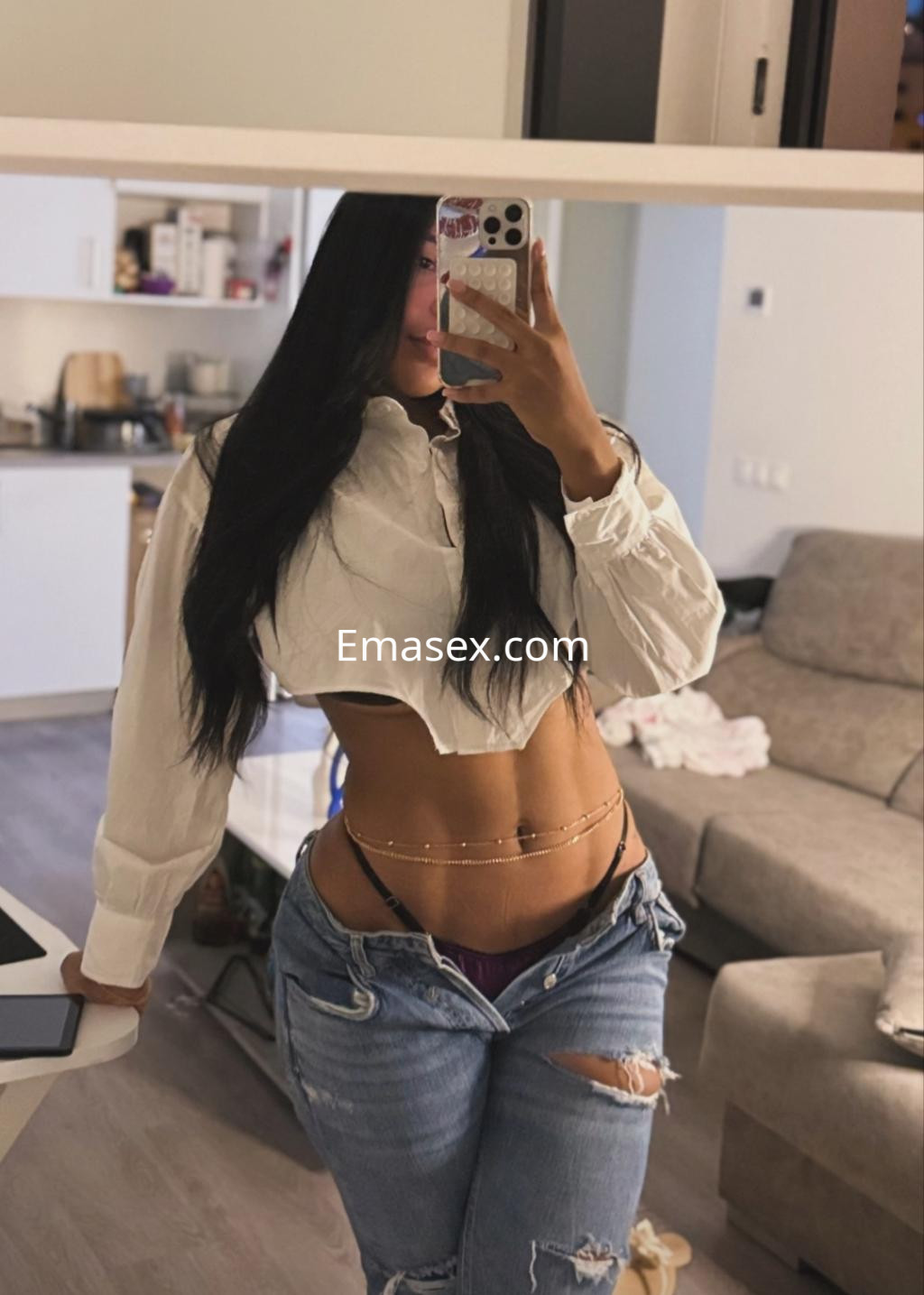 Puta en Valladolid, posando con una blusa blanca corta y jeans desgastados, mostrando su figura.
