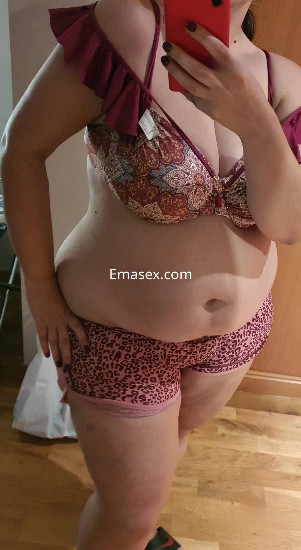Escort en Madrid, luciendo un conjunto de lencería con detalles en estampado, mientras se toma una selfie.