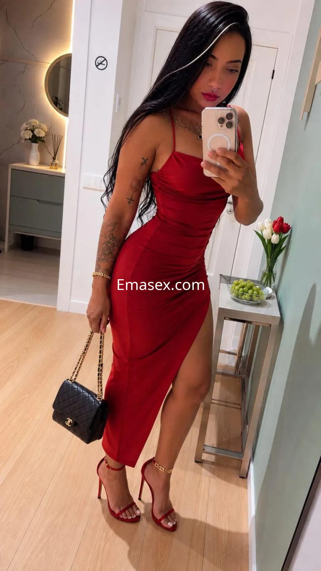 Puta en Palma de Mallorca, posando con un vestido rojo ajustado y tacones, mostrando su figura en un entorno moderno.