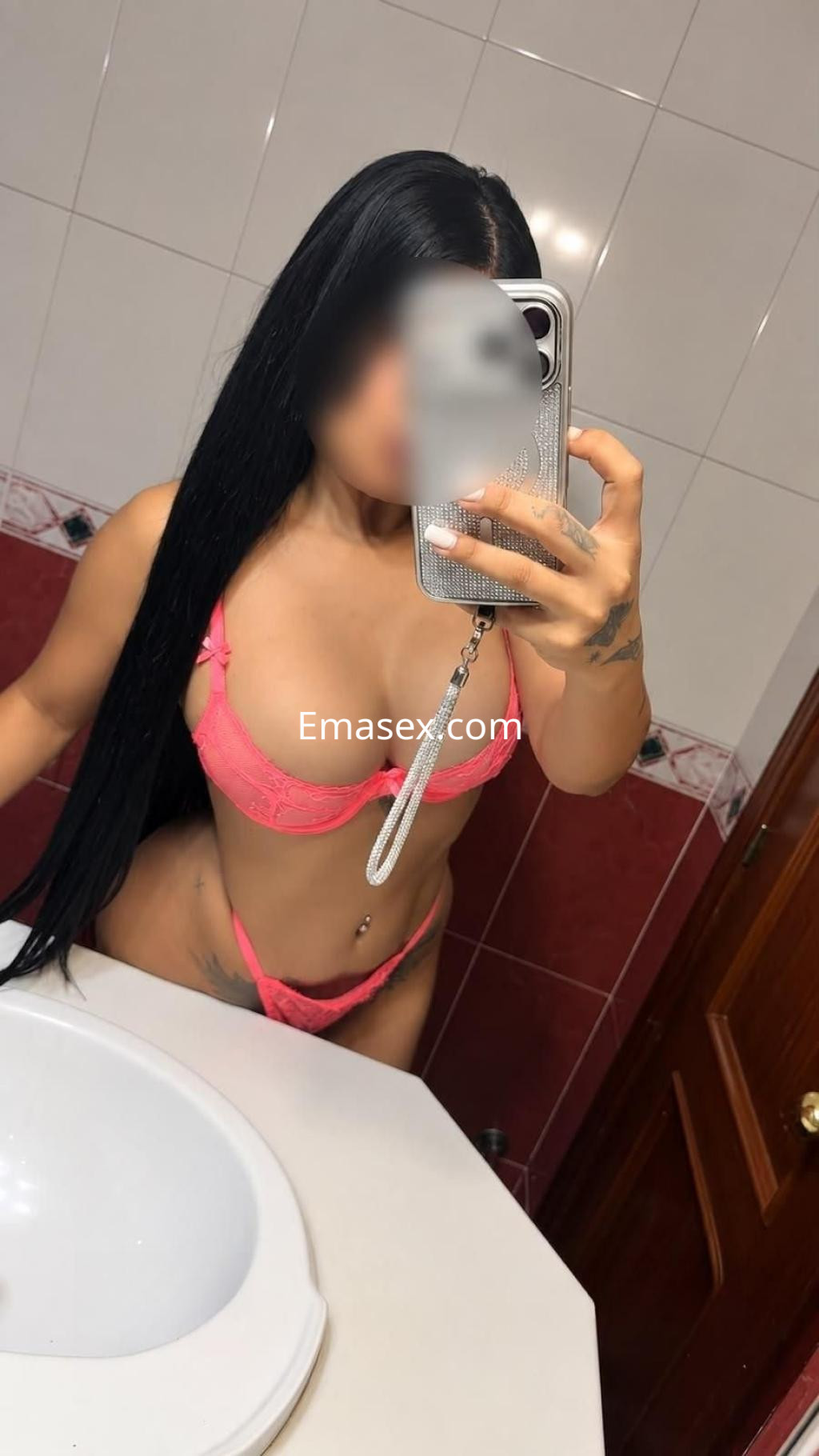 Puta posando en un baño con lencería rosa, cabello largo y liso, mostrando su figura en Sevilla.