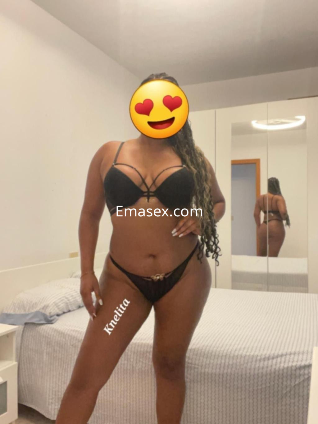 La escort en Cádiz luce un conjunto de lencería negra con detalles en un entorno moderno y minimalista.