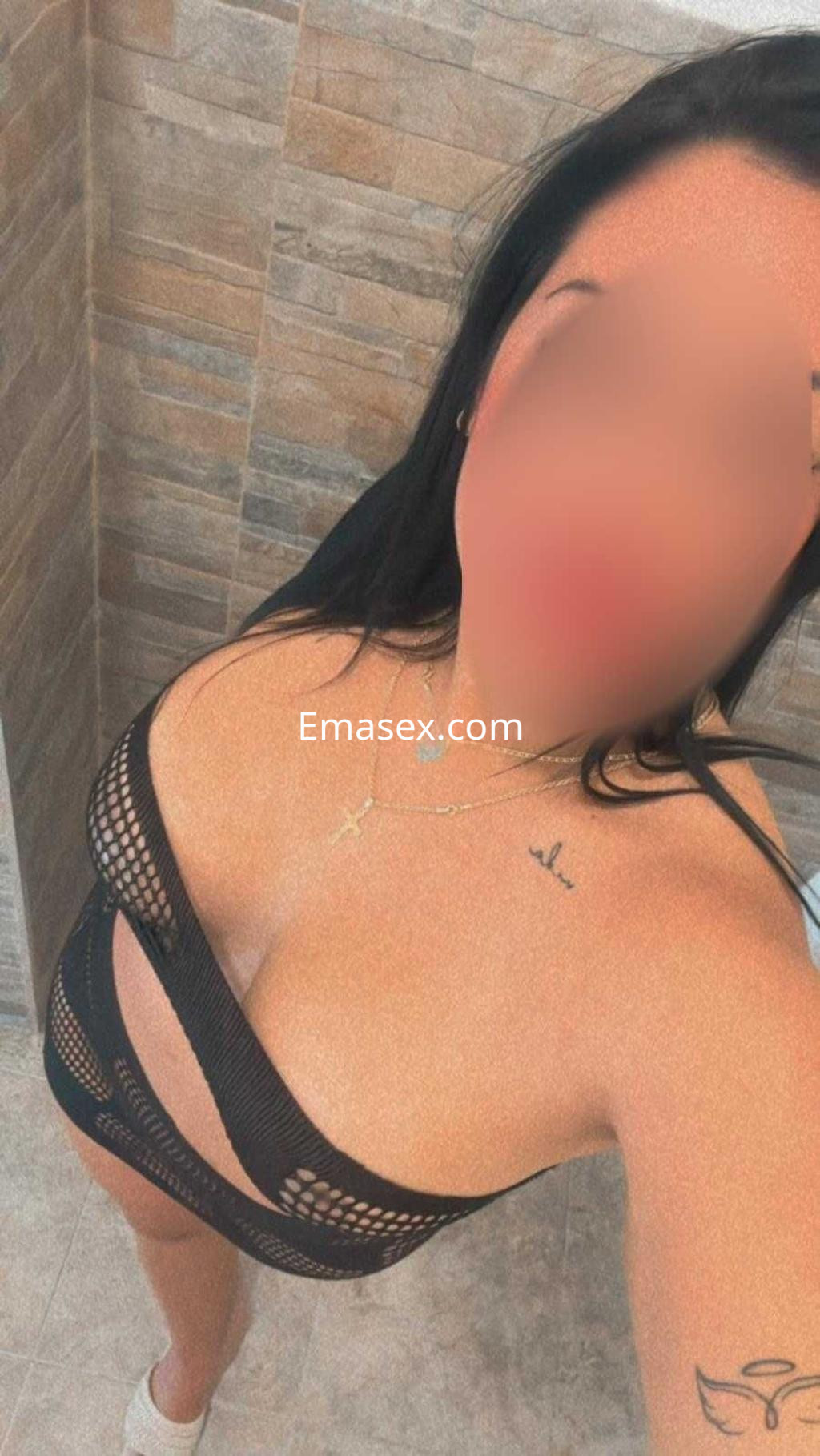 Escort en Murcia con cabello largo y oscuro, vistiendo lencería negra con detalles en red y joyería.